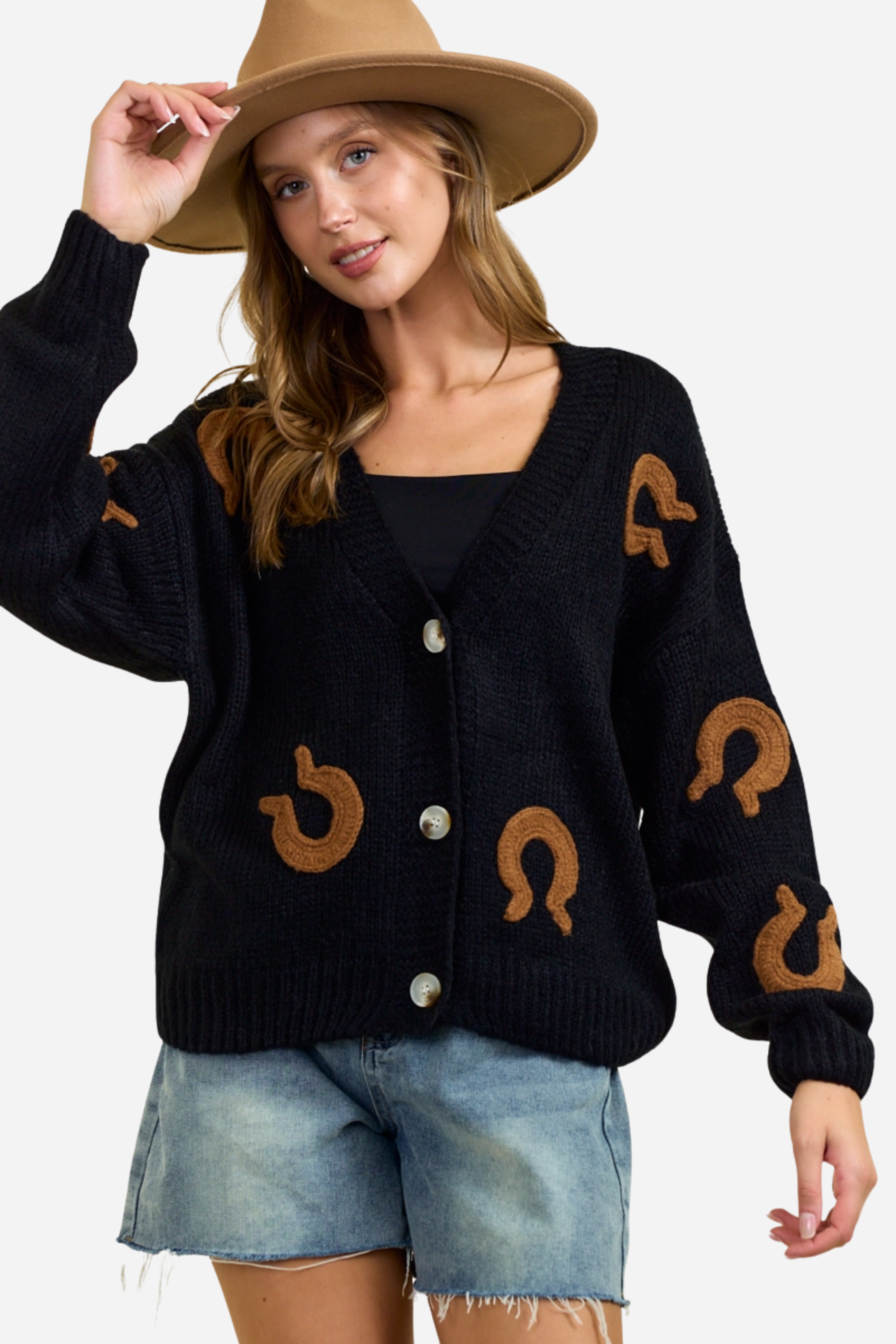 Black chunky knit cardigan with oversized brown horseshoe patches, button-front closure and deep V-neckline, styled casually with denim shorts for a relaxed equestrian-inspired look. equestrian cardigan, horseshoe print sweater, chunky knit cardigan, women’s equestrian fashion, cozy barn outfit, western inspired cardigan, horse lover gift, oversized knit sweater, casual equestrian style, layered fall equestrian look, stylish barn wear, country chic cardigan, horse themed apparel, rustic western sweater