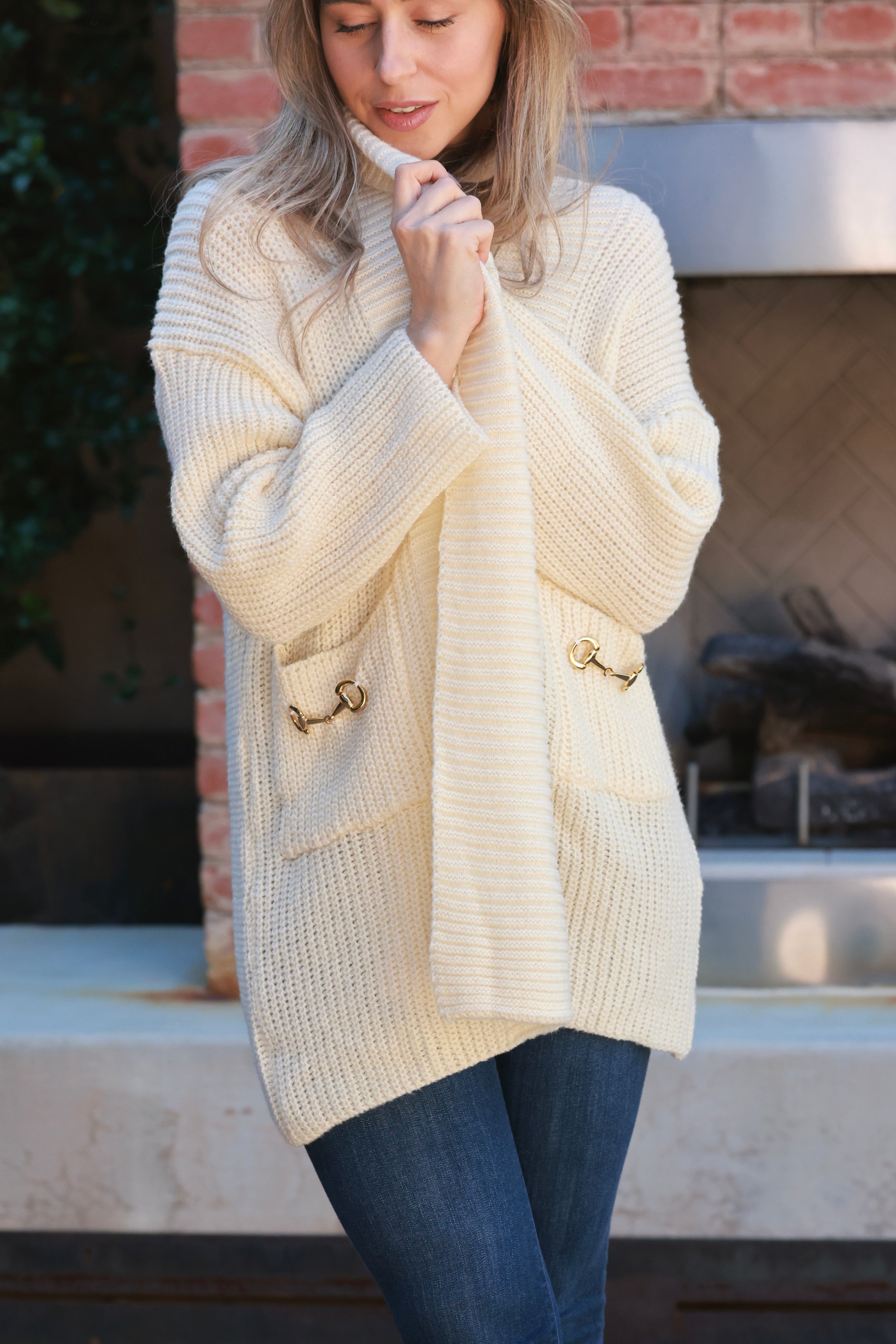 Elegant oversized equestrian cardigan in plush chunky knit with wide fold-over collar and front pockets adorned with gold horse bits. Cozy, luxurious open-front sweater inspired by classic horse girl style — the Aimee Bit Cardigan from Stylish Equestrian.