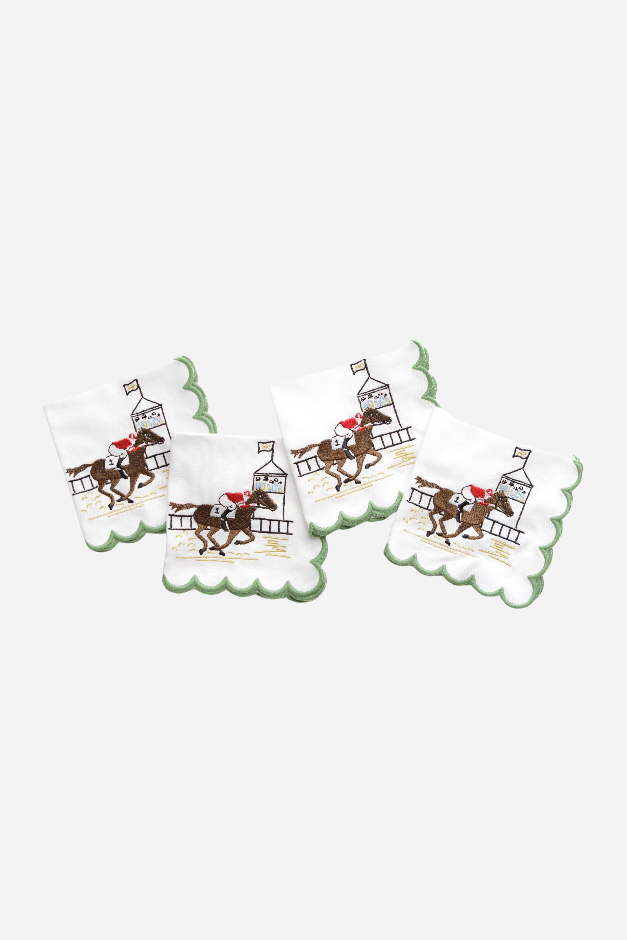 Pomegranate At The Finish Cocktail Napkin Set A toast to the thrill of the track! Our At the Finish Embroidered Cocktail Napkins bring race day excitement to every sip. Featuring a spirited racehorse and jockey charging past the finish line, these embroidered white cotton napkins with a green scalloped edge are a festive nod to the sport of kings—and the queens who throw a fabulous party.
