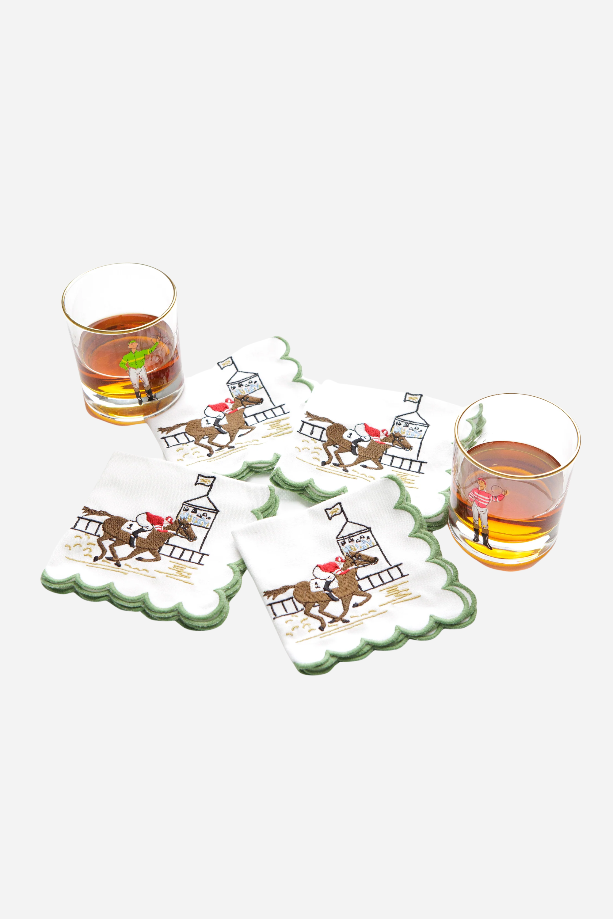 Pomegranate At The Finish Cocktail Napkin Set A toast to the thrill of the track! Our At the Finish Embroidered Cocktail Napkins bring race day excitement to every sip. Featuring a spirited racehorse and jockey charging past the finish line, these embroidered white cotton napkins with a green scalloped edge are a festive nod to the sport of kings—and the queens who throw a fabulous party.