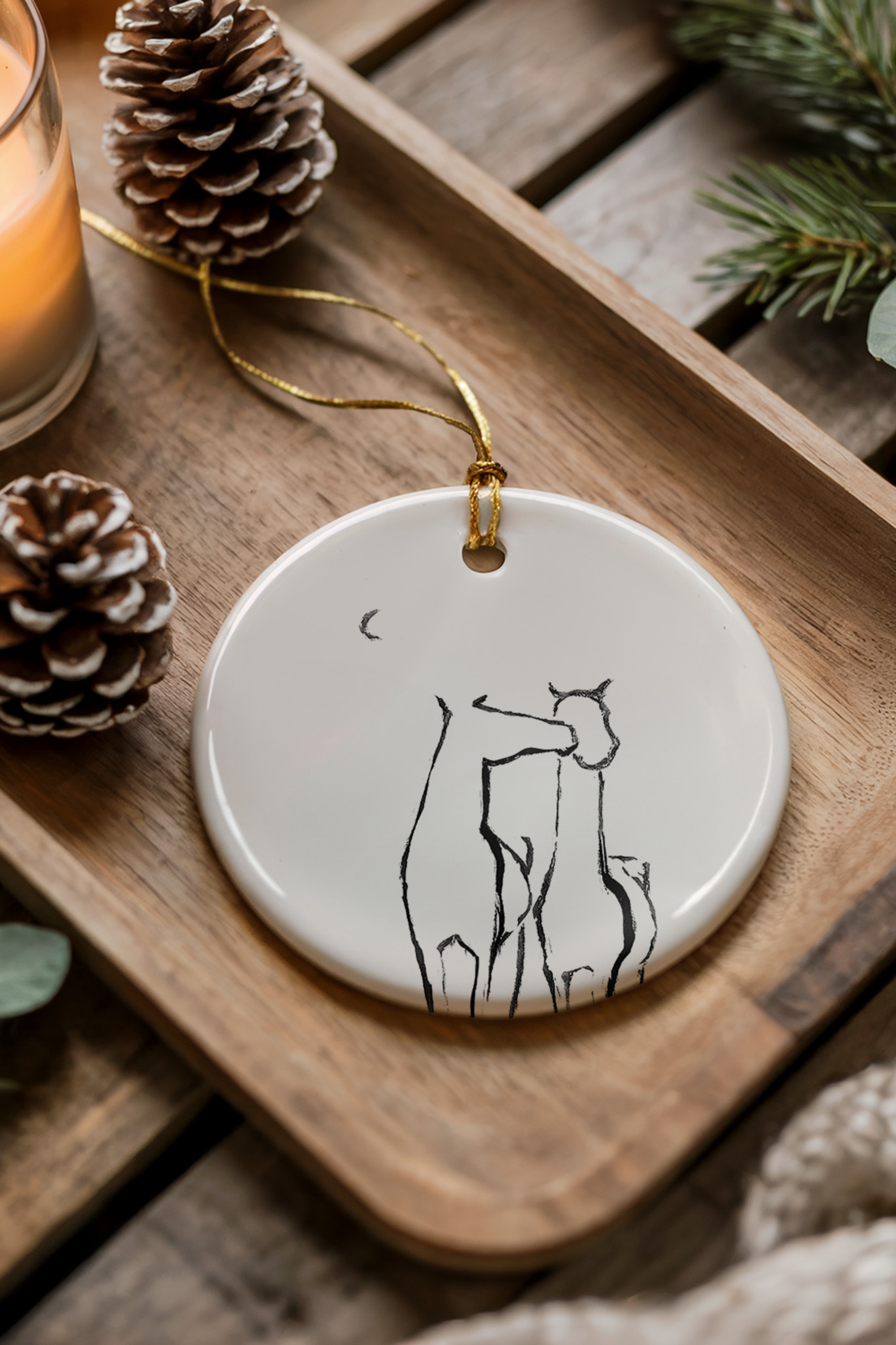 Besos Ornament — ceramic equestrian-inspired Christmas ornament featuring original horse artwork by Bettina, accented with gold tinsel. A charming horse-themed holiday decoration and thoughtful Christmas gift for equestrians and horse lovers. Made in the USA.