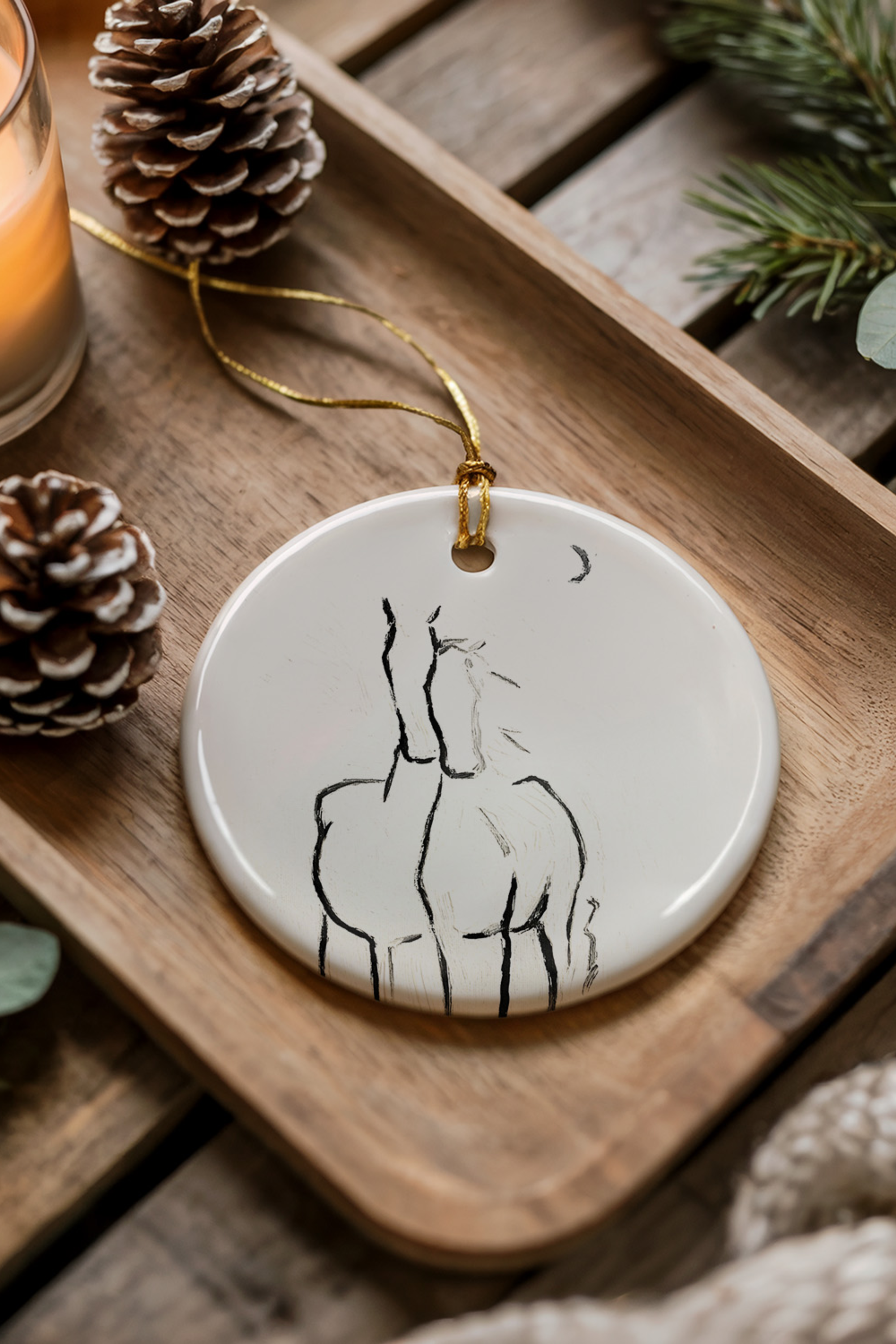 By The Crescent Ornament — ceramic equestrian-inspired Christmas ornament featuring original horse artwork by Bettina, finished with gold tinsel. A beautiful horse-themed holiday decoration and perfect Christmas gift for equestrians and horse lovers. Made in the USA.