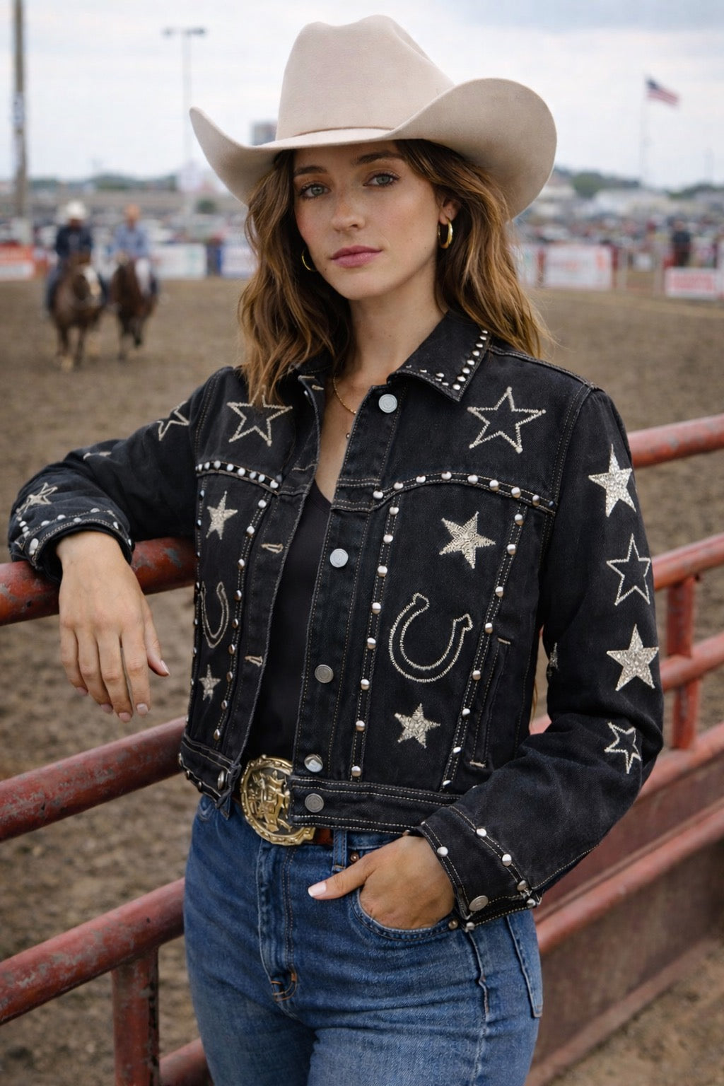 Black cotton denim jacket with all-over equestrian and western-inspired embroidery, including horseshoes and stars, accented with metallic rivet detailing.