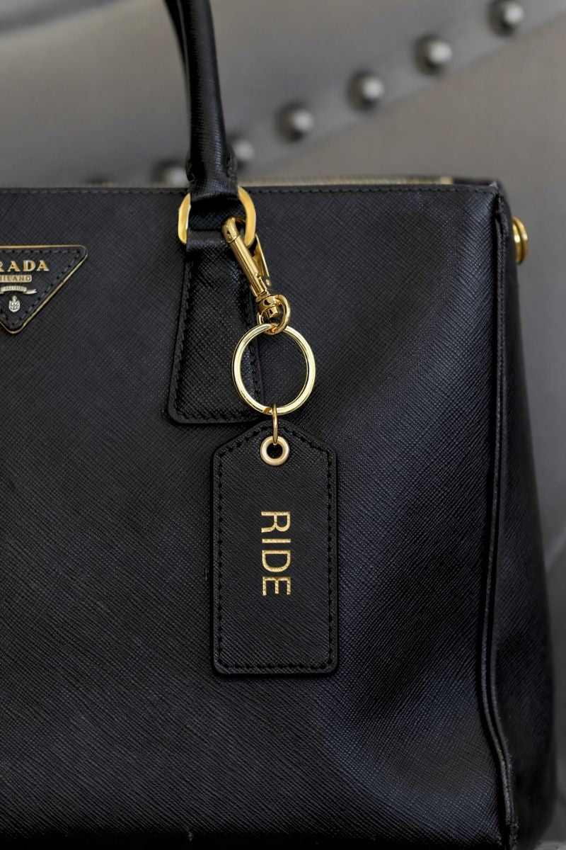 Cleo equestrian key ring in black pebbled leather featuring gold foil equestrian design and gold-tone snap hook