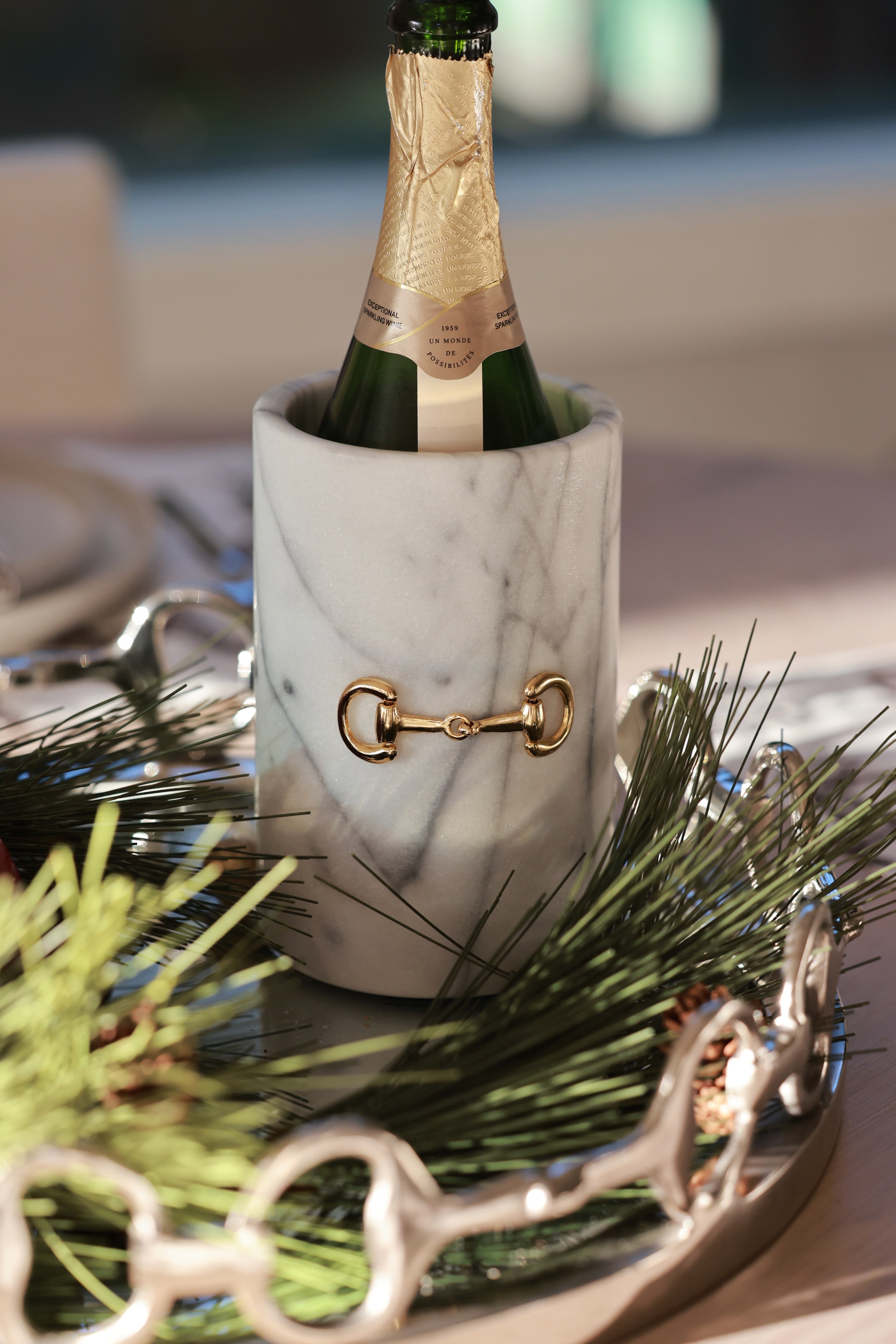 Handcrafted white marble D-ring cylinder with polished gold horse bit hardware, styled in an elegant equestrian kitchen. The sleek matte marble vessel doubles as a wine chiller, utensil holder, or flower vase, featuring natural veining and timeless horse-inspired detailing for a sophisticated home accent.