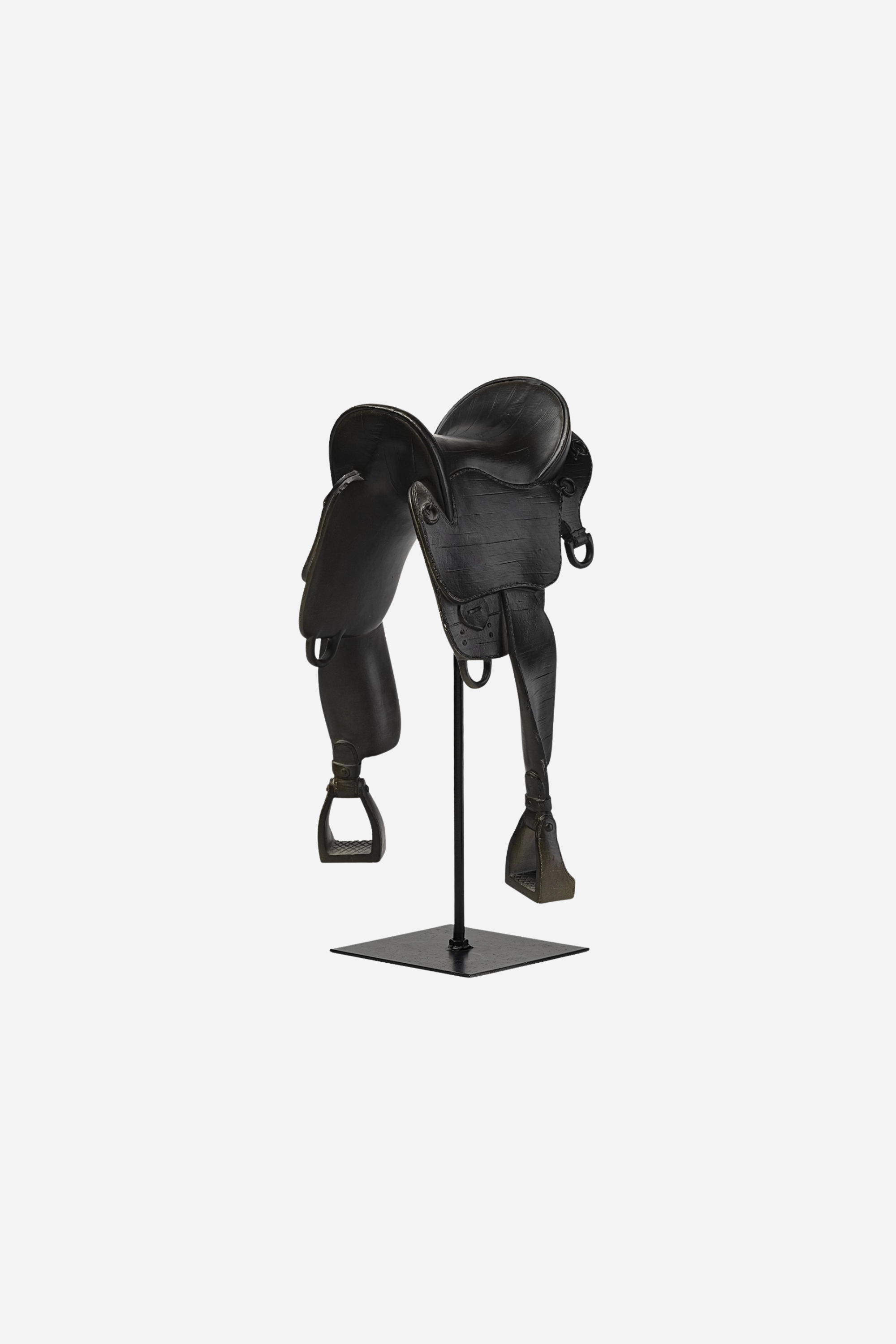 A matte black English-style equestrian saddle decor piece crafted from resin and metal, featuring fine detailing that mimics real saddle stitching and hardware. The saddle sits atop a sleek black metal rod and square base, standing 17 inches tall. Its minimalist, modern design evokes traditional riding gear while serving as a bold centerpiece for equestrian-themed home decor.