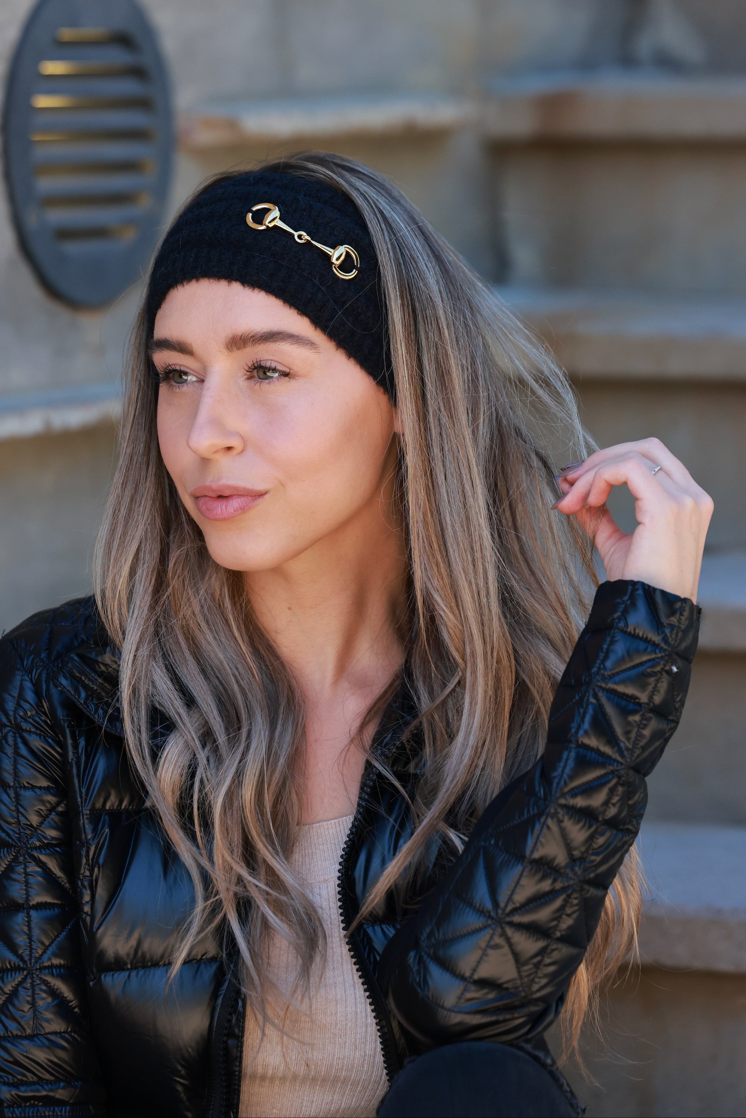 Black Elsie Knit Headband featuring soft, stretchy knit fabric and a gold bit accent. Comfortable, secure fit adds a touch of equestrian elegance to any cold-weather look.