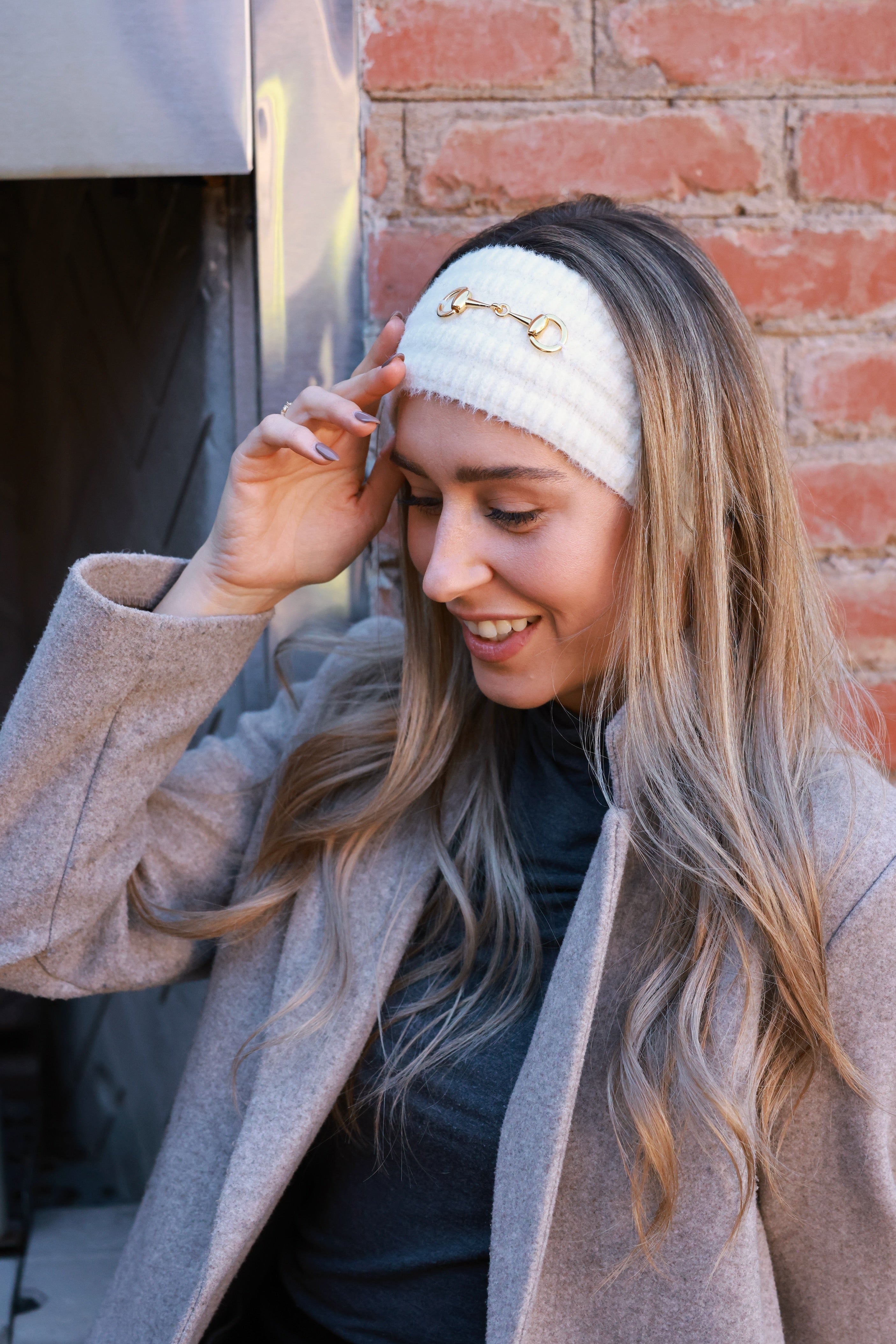 Ivory Elsie Knit Headband crafted from soft, stretchy knit with a gold bit accent. Comfortable, secure fit adds equestrian elegance to cold-weather outfits — perfect for barn mornings or casual rides.