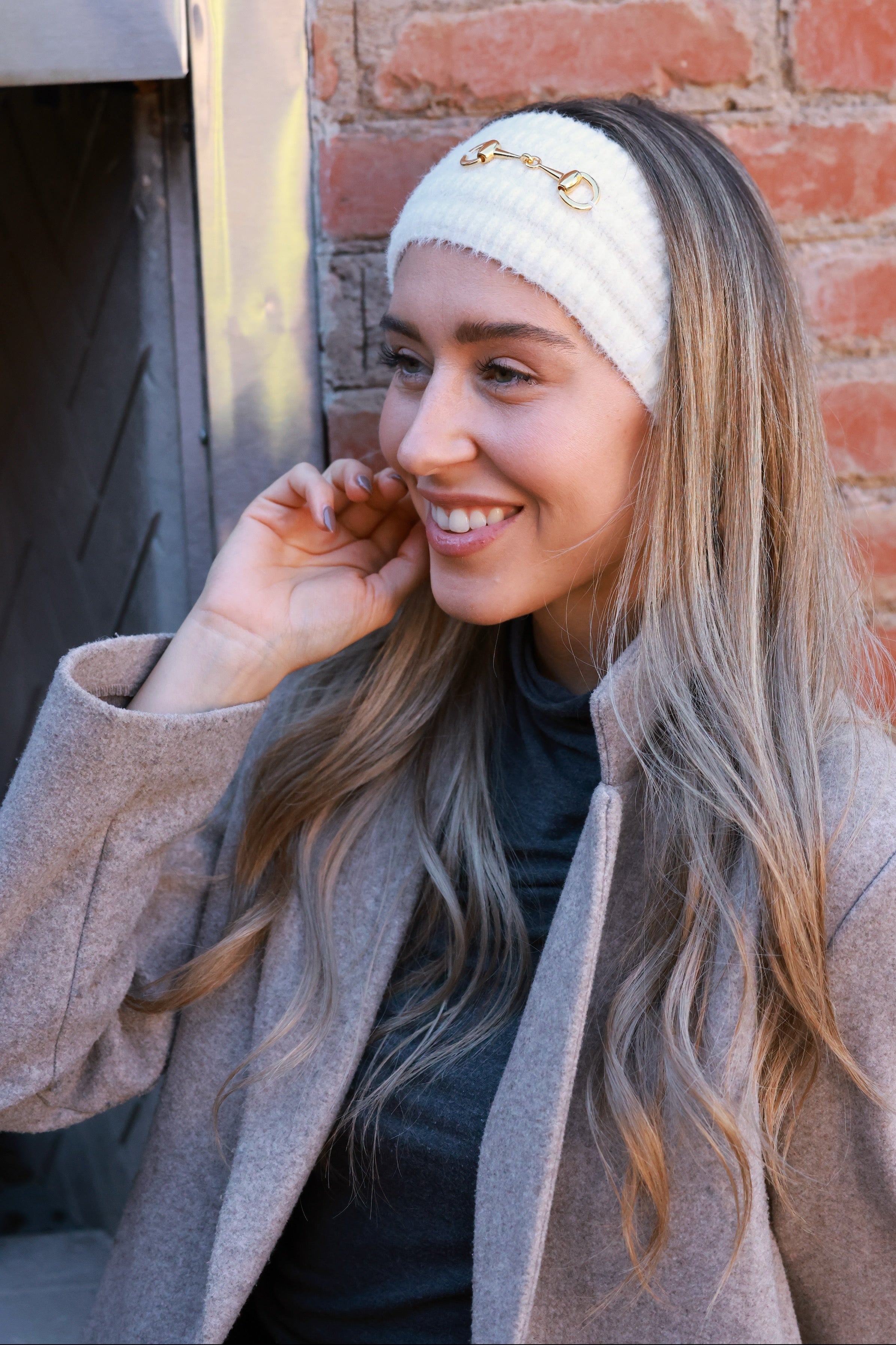 Ivory Elsie Knit Headband crafted from soft, stretchy knit with a gold bit accent. Comfortable, secure fit adds equestrian elegance to cold-weather outfits — perfect for barn mornings or casual rides.