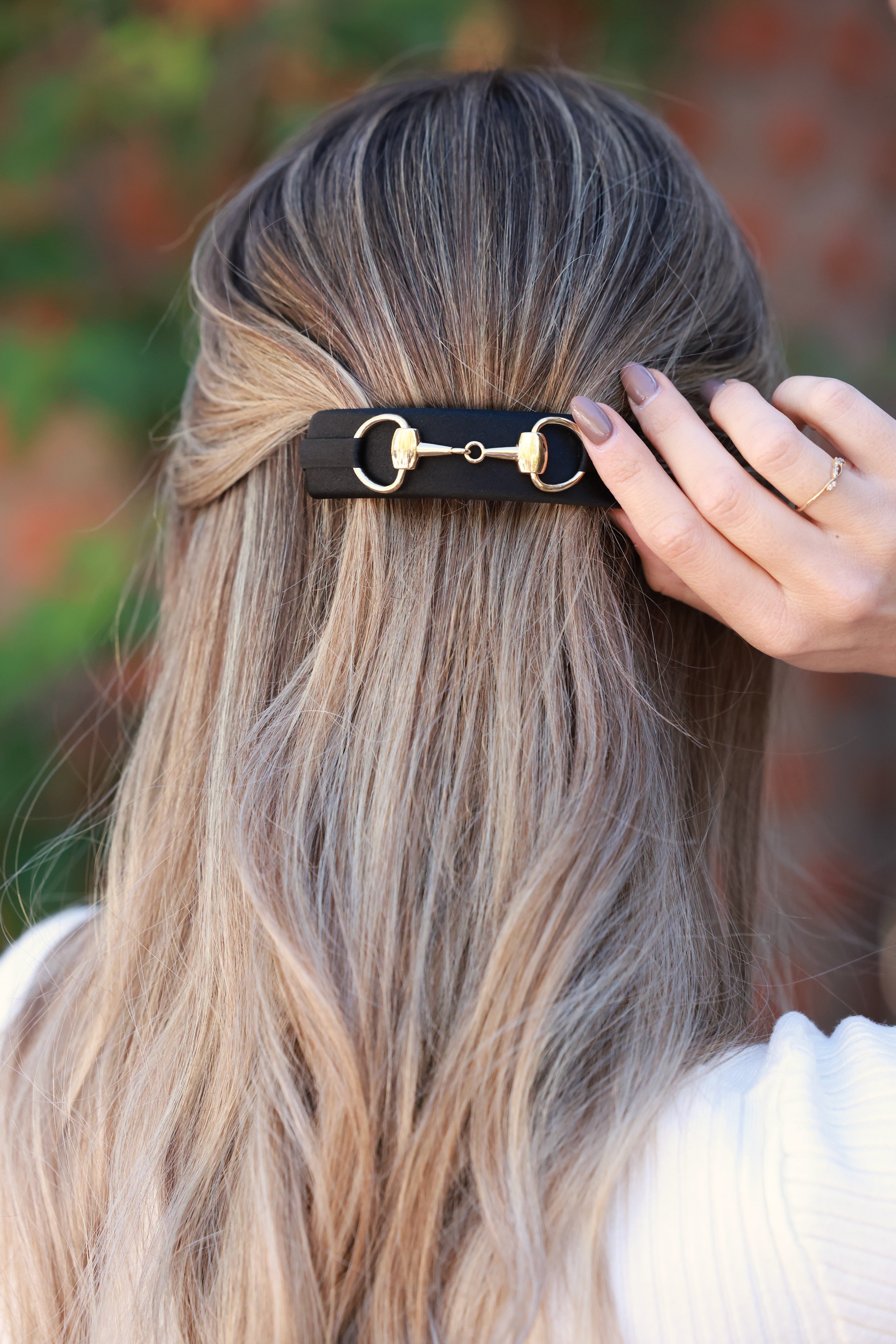Black Hattie Bit Silk Barrette handcrafted in 100% silk charmeuse, featuring a large gold snaffle bit detail and sturdy clasp for thick hair. Elegant equestrian-inspired accessory that adds everyday chic and timeless sophistication to any hairstyle.