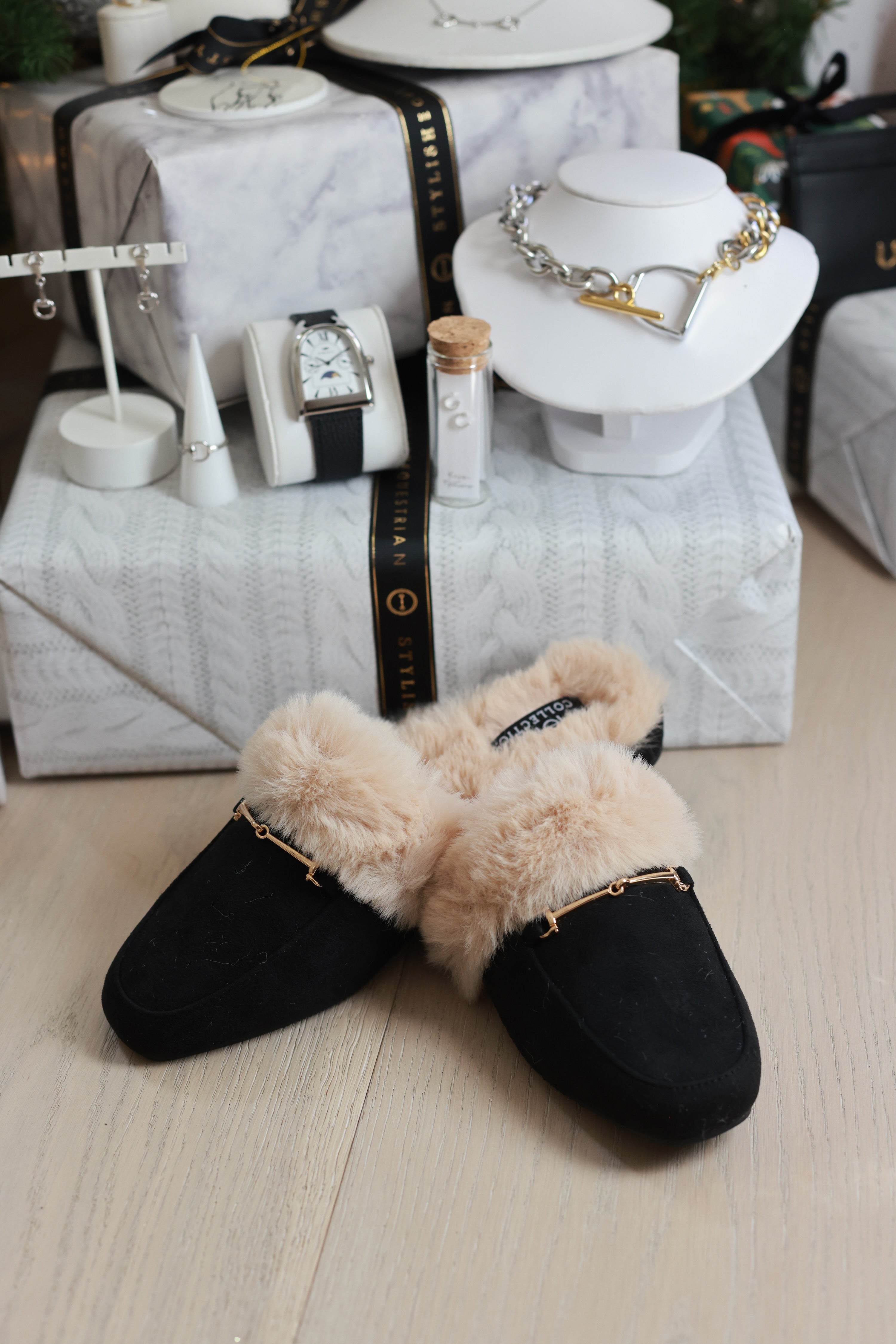 Pair of black slippers with beige fur on a white background - Women’s loafer slippers, Faux-fur lined mules, Black slip-on loafers, Cozy fashion slippers, Women’s bit loafers, Plush indoor outdoor slippers, Women’s mule slippers, Chic faux-fur loafers, Backless loafer-style mules, Stylish lounge slippers