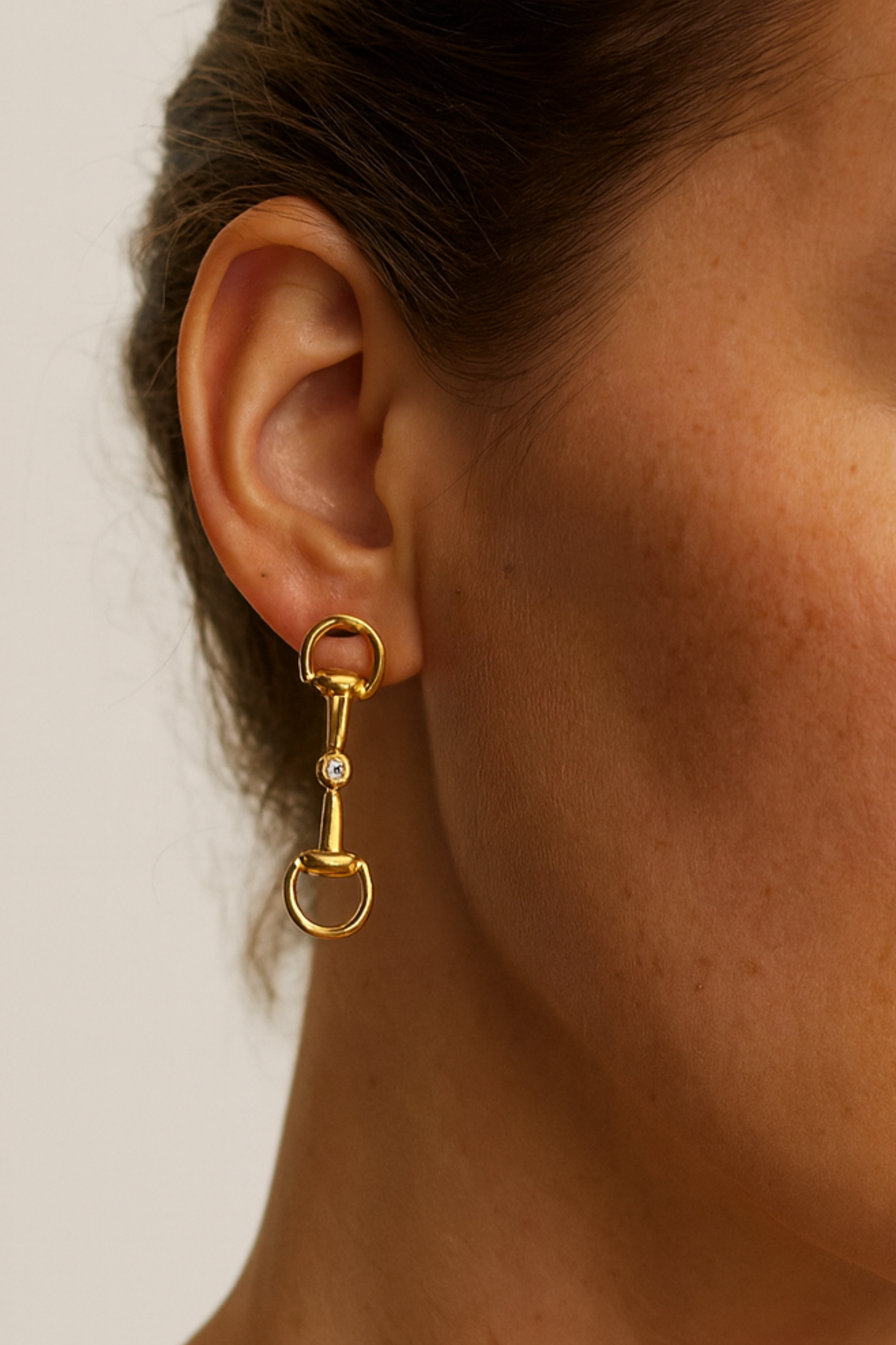 Gold equestrian bit drop earrings with crystal accents, lightweight 18k gold horse girl jewelry, dainty CZ stud earrings, elegant gift for equestrian lovers.