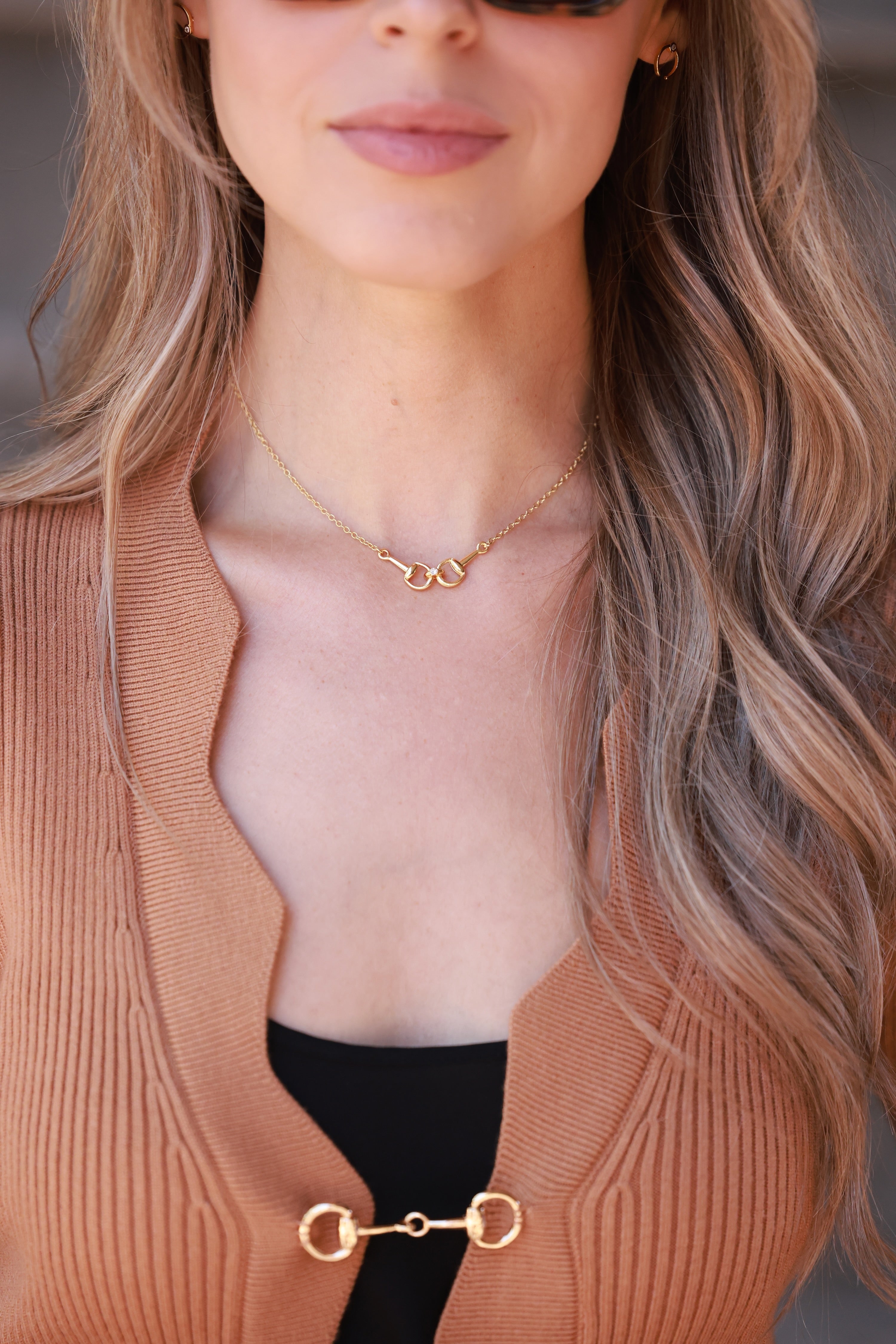 Close-up of a person wearing a gold necklace with a neutral background - equestrian inspired jewelry, horse girl accessory, horseshoe pendant necklace, dainty equestrian jewelry, small gifts for horse lovers