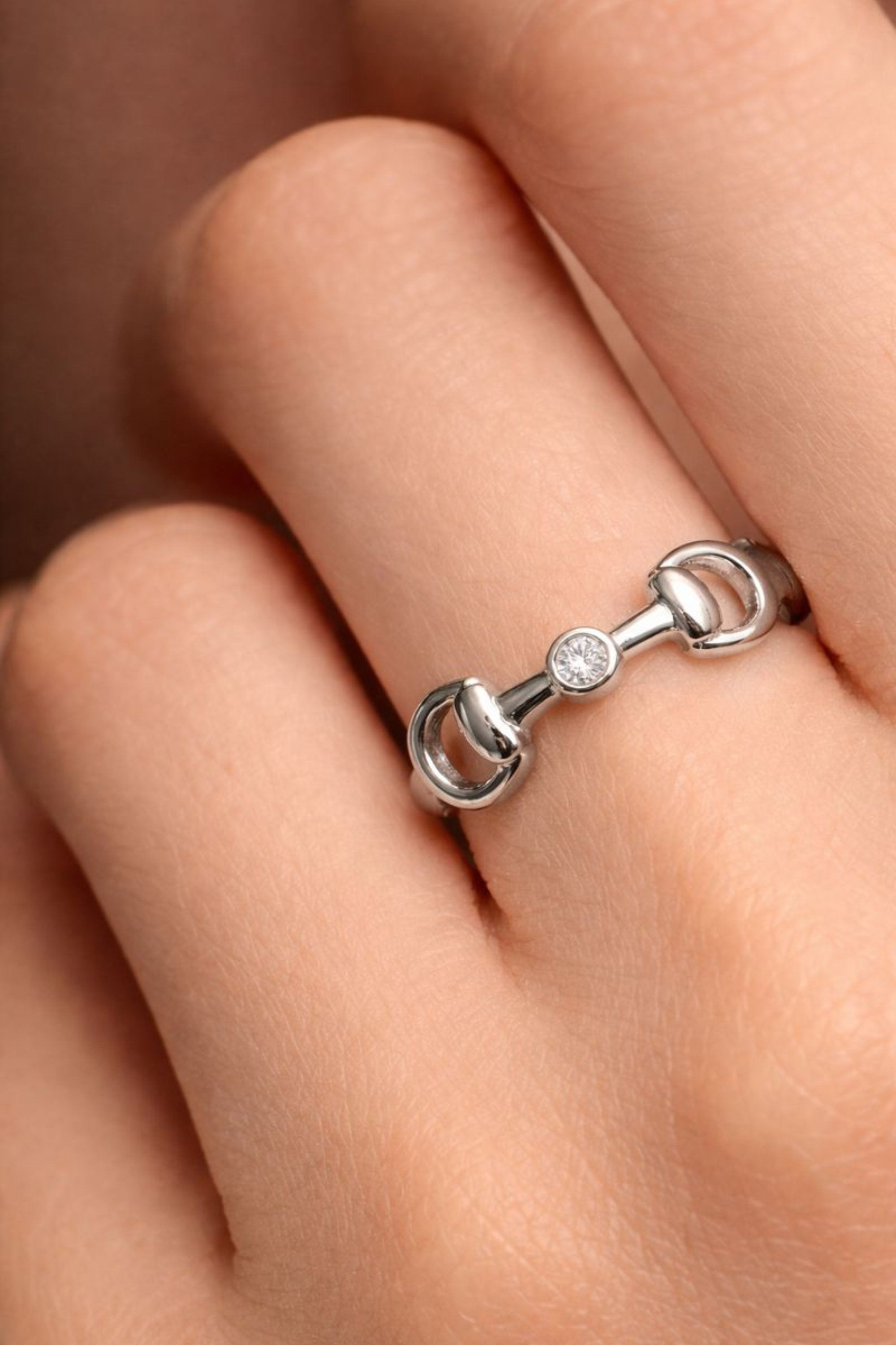 Polished silver horse bit ring with a bezel-set crystal accent, inspired by equestrian design and crafted for everyday wear.