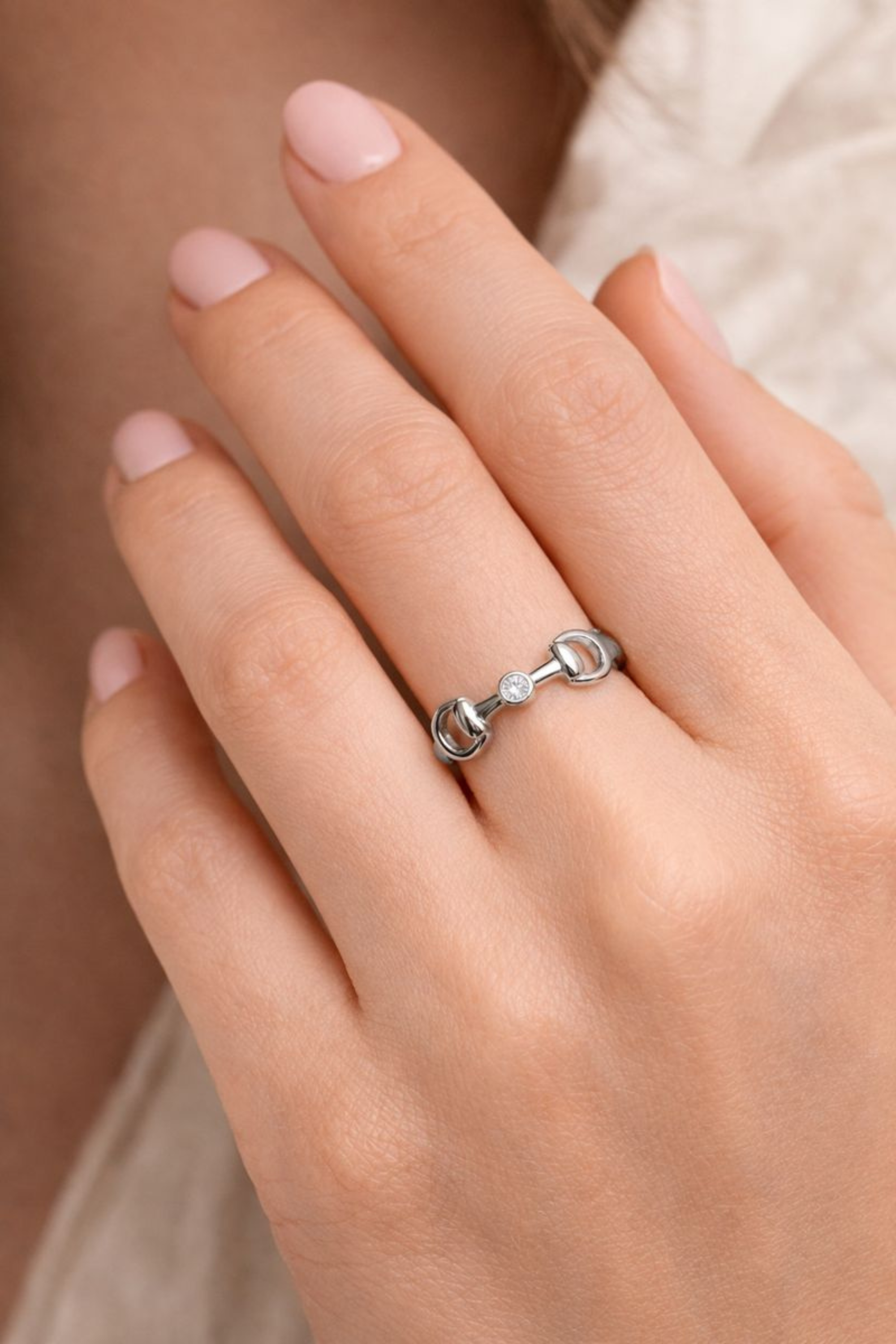 Polished silver horse bit ring with a bezel-set crystal accent, inspired by equestrian design and crafted for everyday wear.
