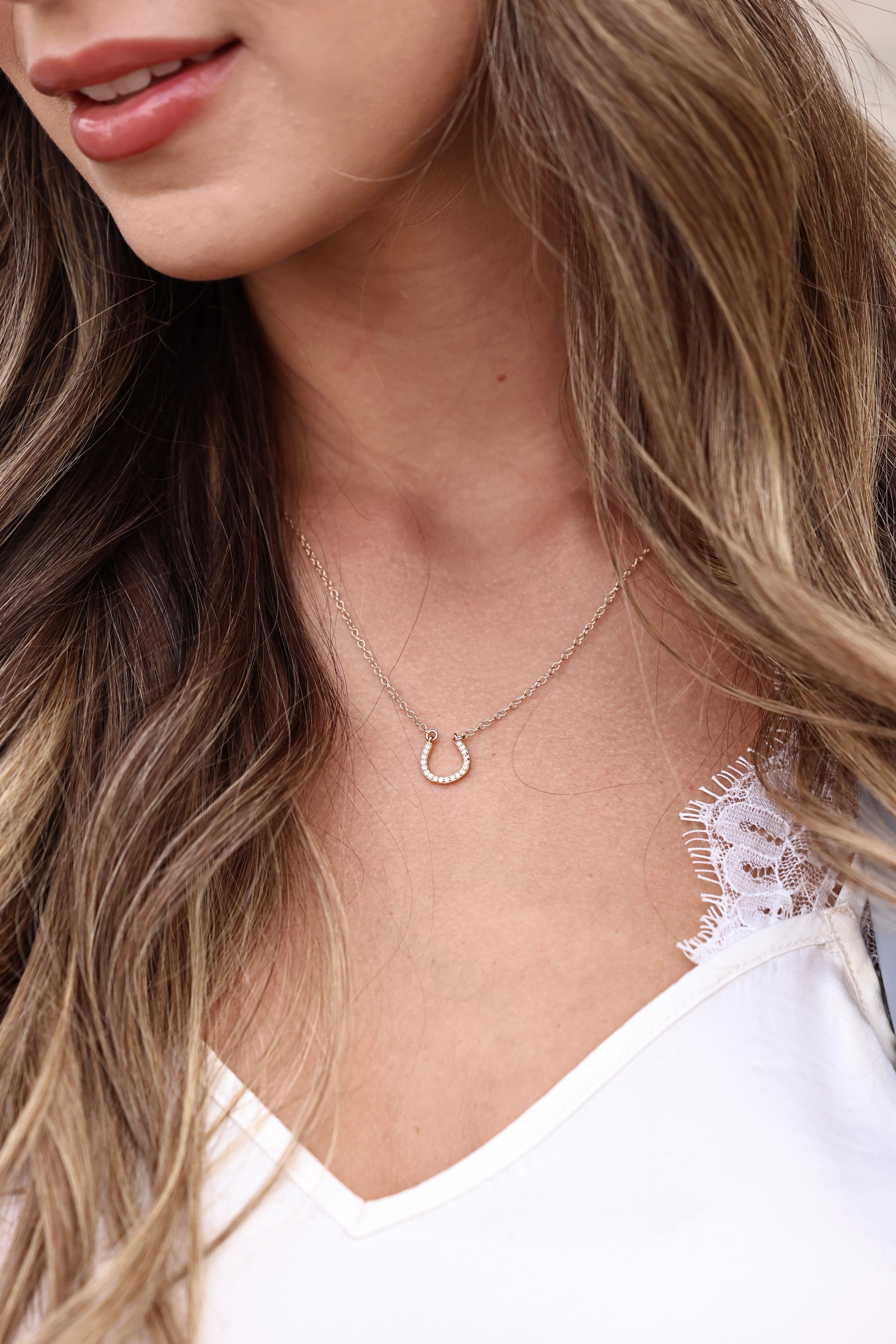 Dainty pavé horseshoe necklace featuring an 18k gold vermeil charm and adjustable chain, perfect for layering.