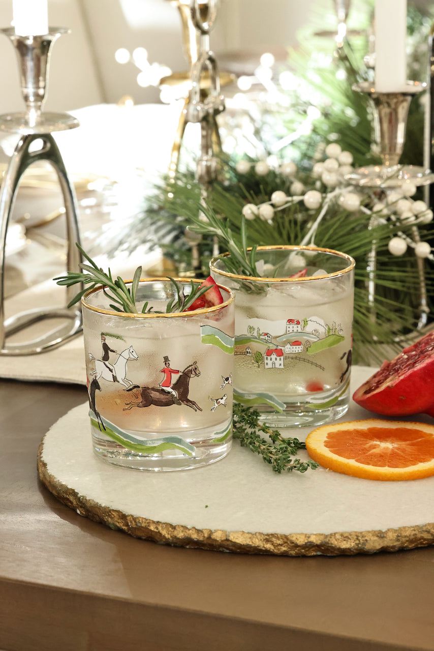 The Hunt Scene Drinking Glass Set featuring four tall glasses adorned with a detailed equestrian hunt scene and finished with elegant gold rims. A sophisticated horse-themed glassware set perfect for entertaining or gifting.