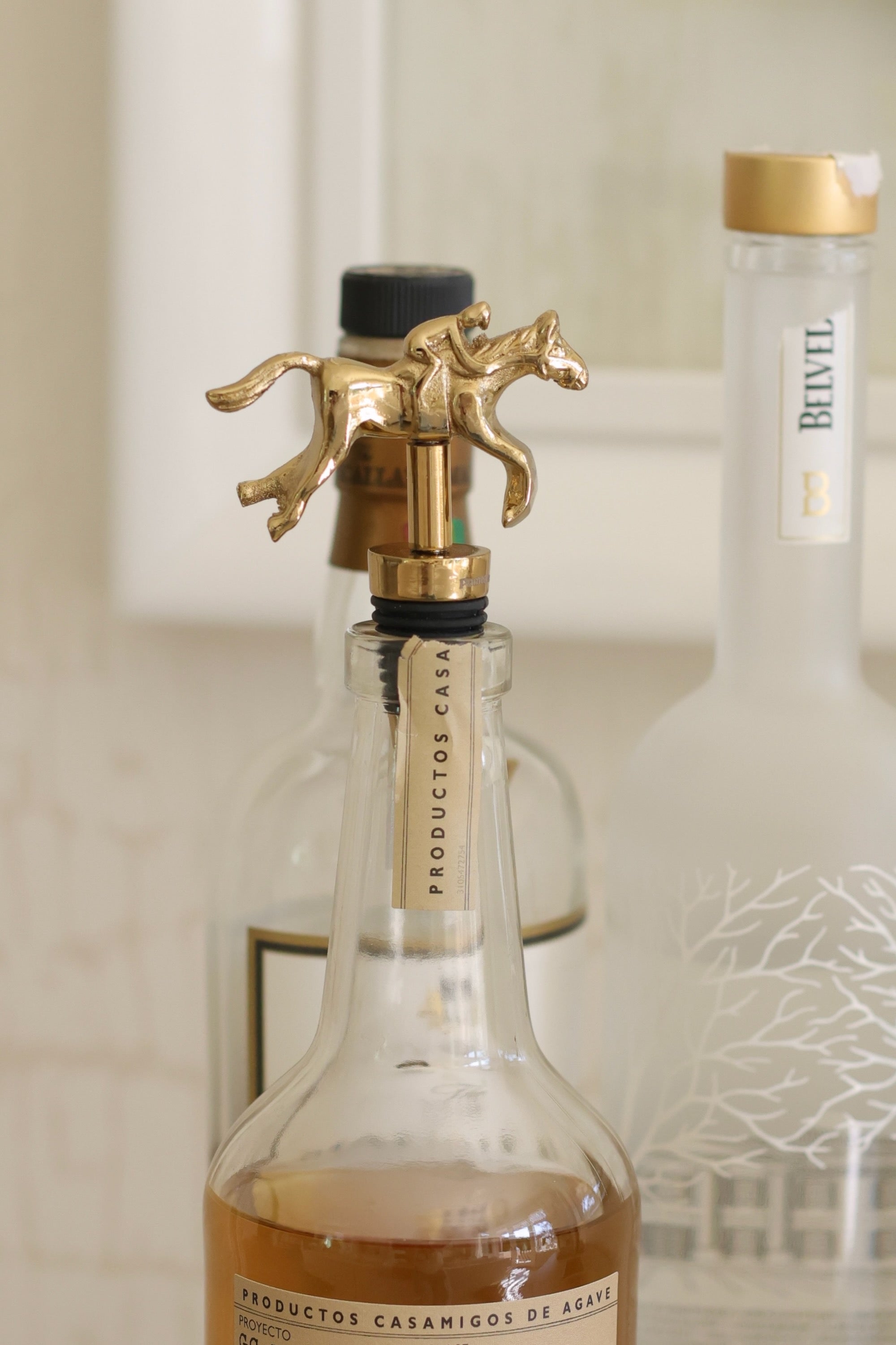 Pomegranate Jockey Bottle Stopper - Gold Elevate your entertaining with the Gold Jockey Bottle Stopper. Crafted with a charming horse & jockey design, this stopper not only preserves your wine's freshness but also adds a touch of equestrian elegance to your barware. Its durable construction ensures a secure fit, making it a delightful gift for horse lovers and wine enthusiasts alike.