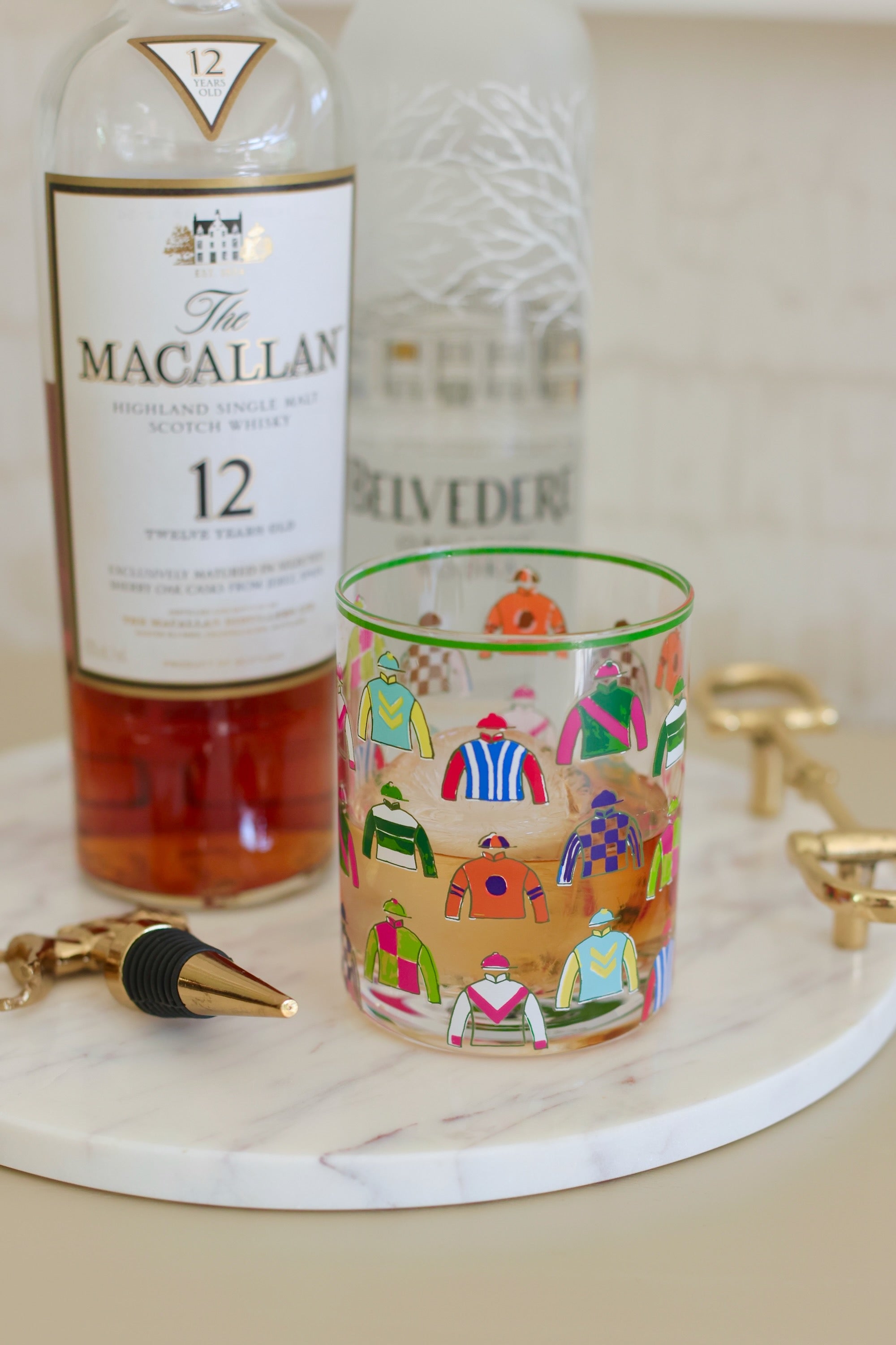 Pomegranate Jockey Silks Short Drinking Glass Set Get ready for the races with the Jockey Silks Bourbon Glass set. Each glass in this set of four is wrapped in a vibrant parade of racing silks, reminiscent of Derby Day at Churchill Downs or a crisp autumn afternoon at Keeneland. Whether you’ve got a colt in the running or you’re just here for the juleps, these glasses are a sure bet for any gathering.