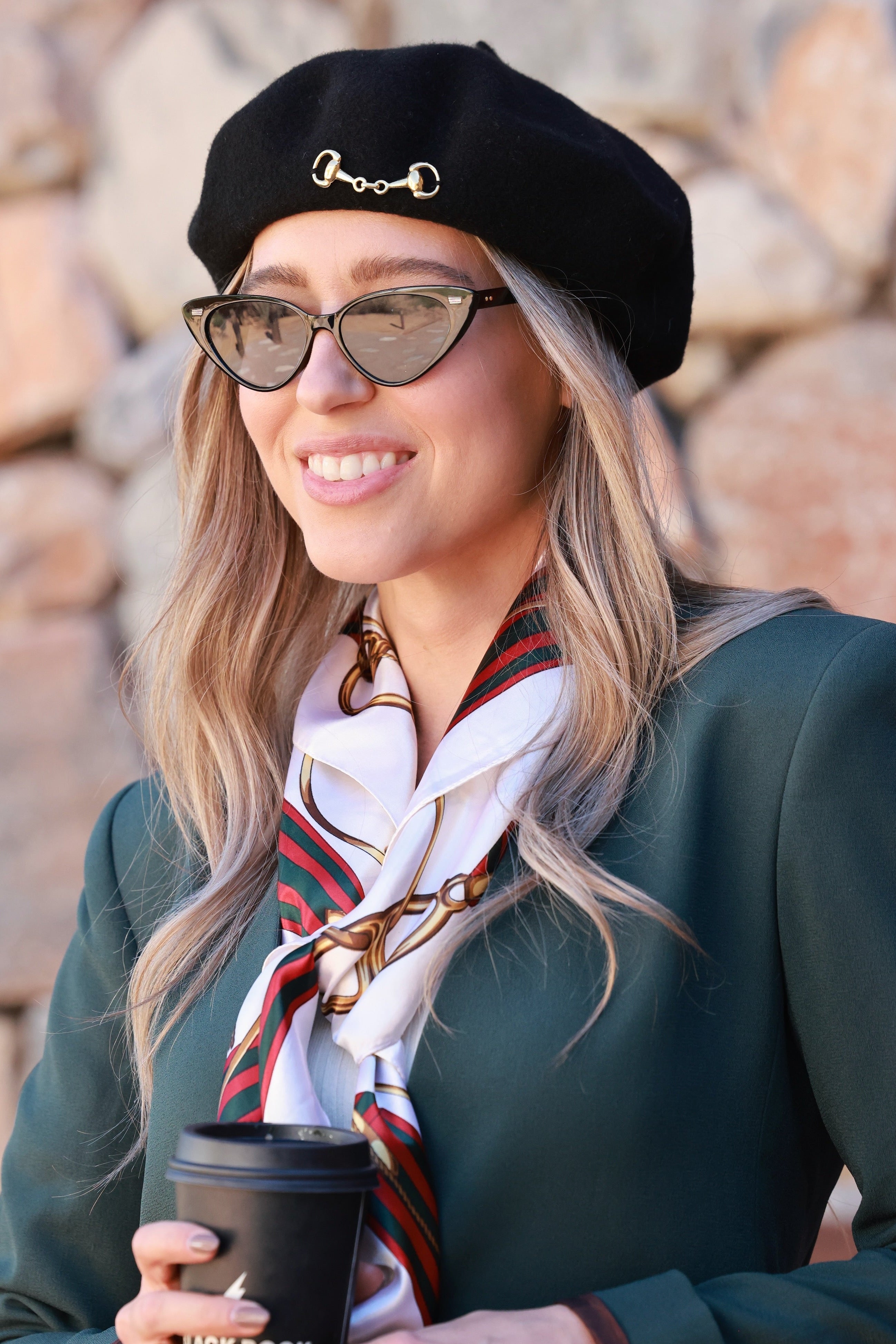 Black Lola Bit Beret crafted from 100% wool and adorned with a polished gold horse bit accent. A timeless equestrian-inspired accessory that adds chic sophistication to any fall or winter look.