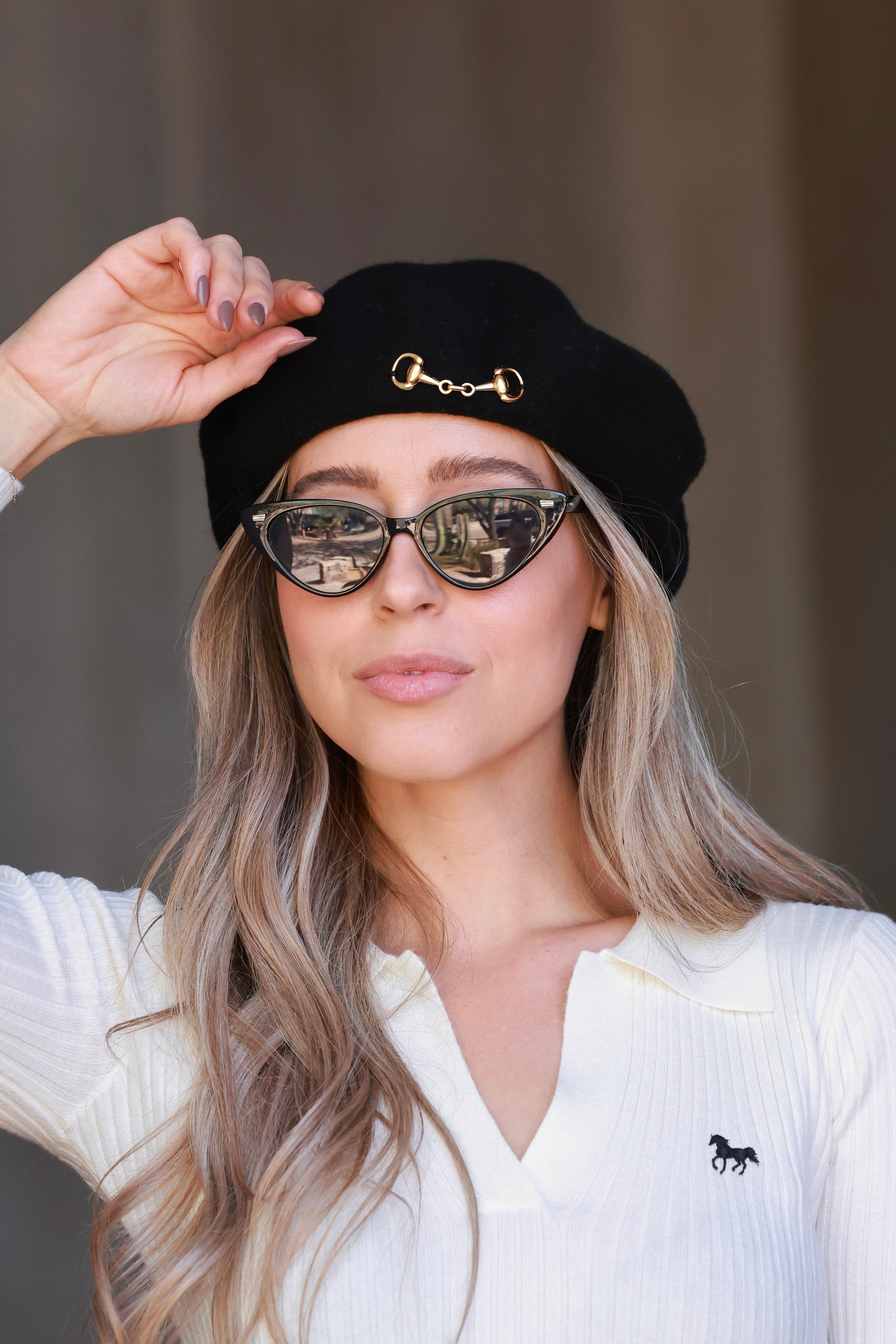 Black Lola Bit Beret crafted from 100% wool and adorned with a polished gold horse bit accent. A timeless equestrian-inspired accessory that adds chic sophistication to any fall or winter look.
