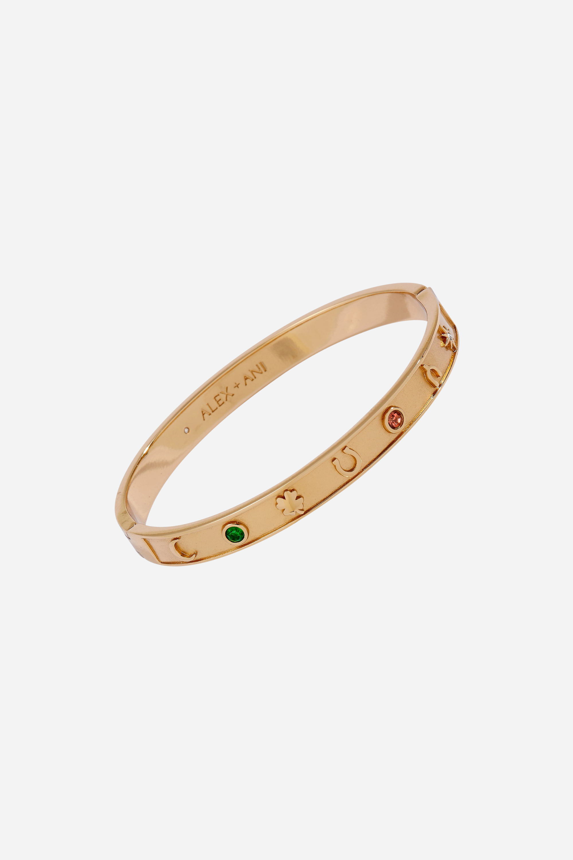 Gold hinge bangle bracelet featuring lucky charm symbols—horseshoe, wishbone, and four-leaf clover—accented with colored crystal details.