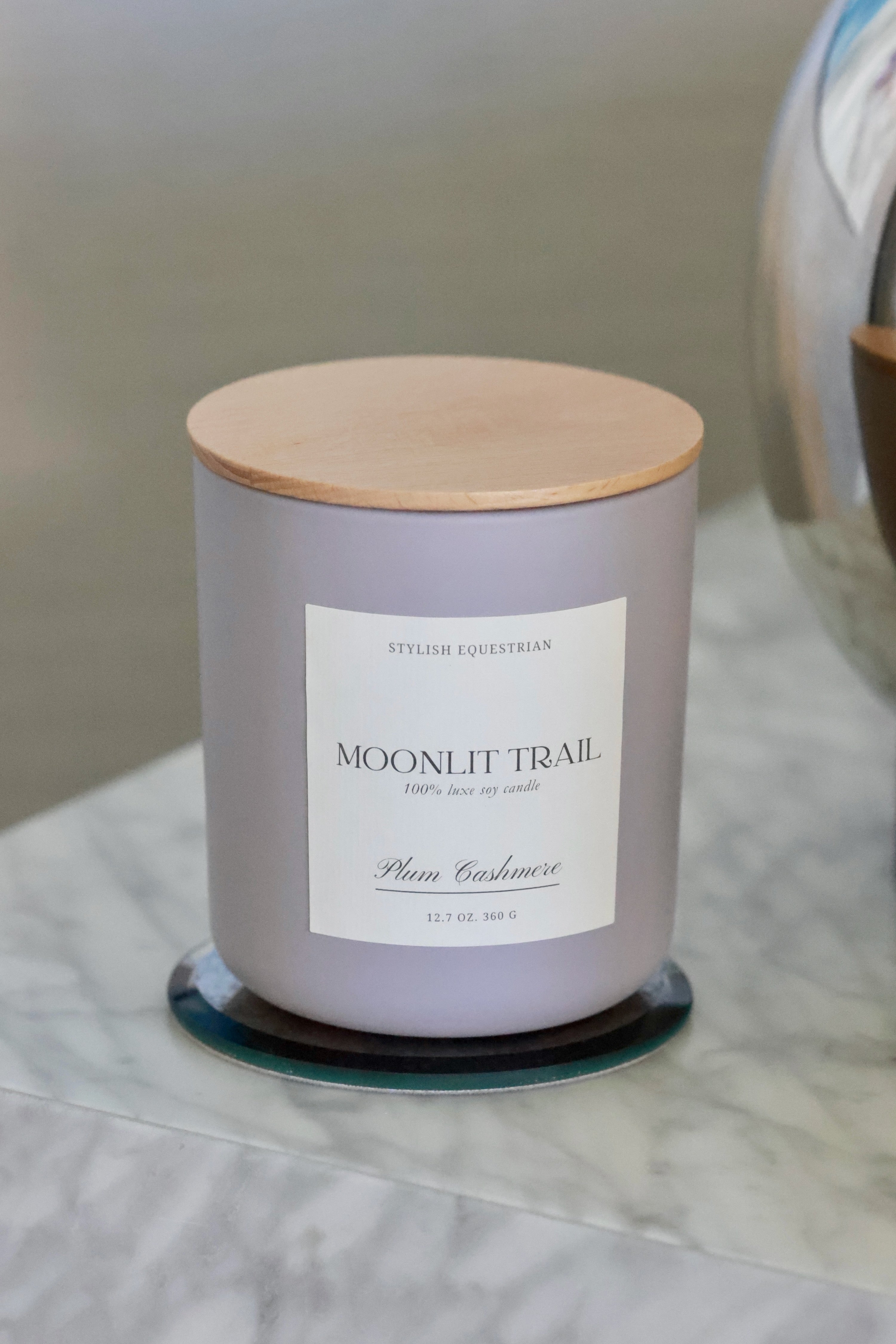 Luxe Signature Candle – Moonlit Trail edition, a handmade 100% soy wax candle in a frosted matte glass vessel with wooden lid. Features a luxurious plum cashmere scent with notes of ripe plum, freesia, warm vanilla, and soft cashmere. Elegant equestrian-inspired home décor accent with 60+ hour burn time. Made in the USA equestrian decor and home accents, horse themed candle, gifts for horse lovers, luxury soy candle, plum cashmere scented candle, Moonlit Trail candle, equestrian home fragrance