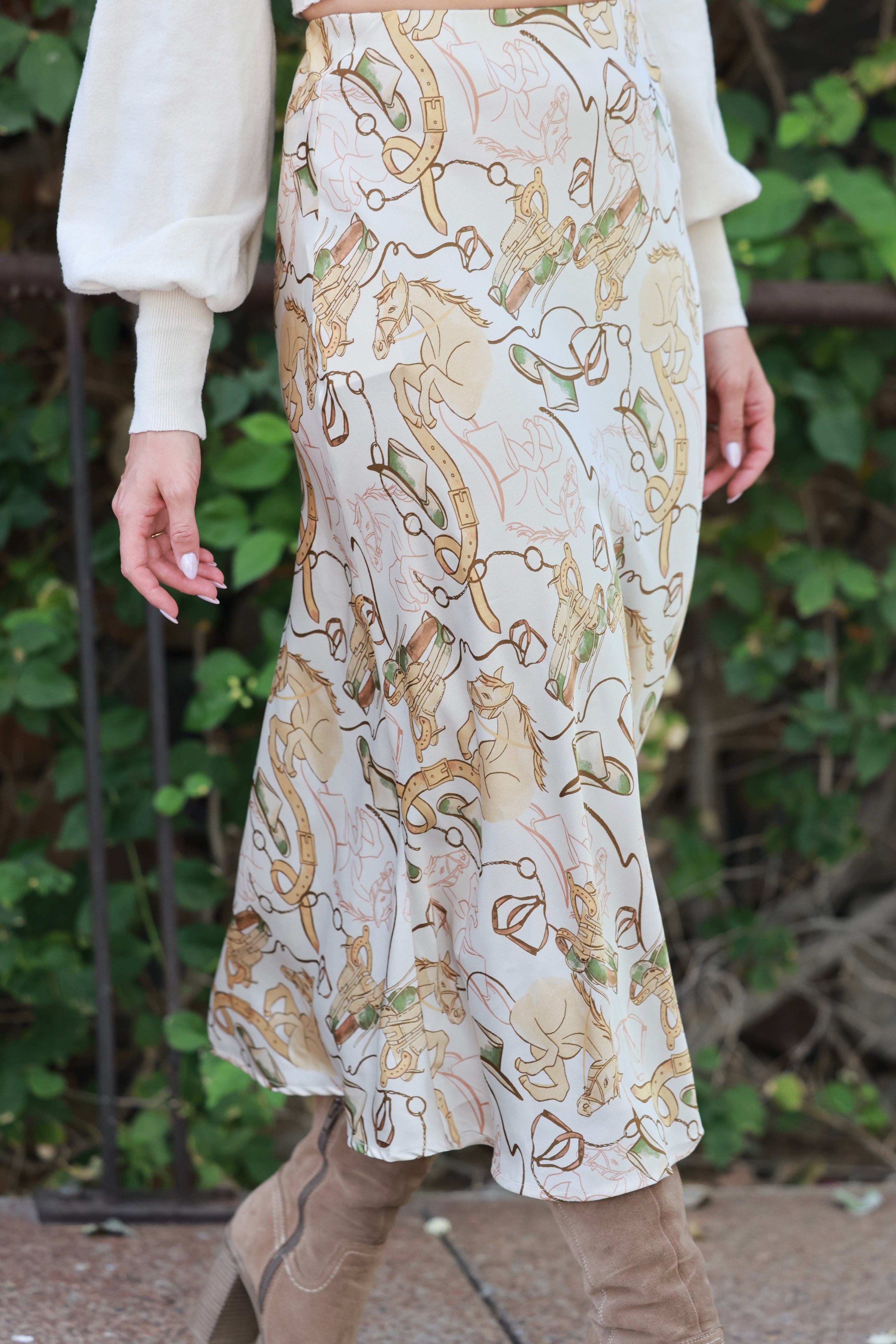 Person wearing a patterned skirt with a neutral background - Western satin midi skirt, &merci exclusive, Cowgirl print slip skirt, Equestrian-inspired fashion, Fall rodeo outfit