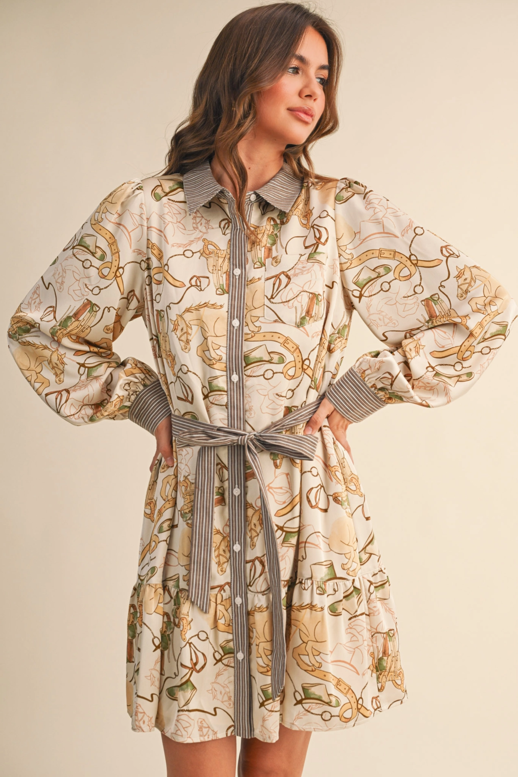 Woman wearing a patterned dress with a belt against a beige background - print mini dress, &merci exclusive, Cowgirl print dress, Equestrian-inspired dress, Fall rodeo outfit