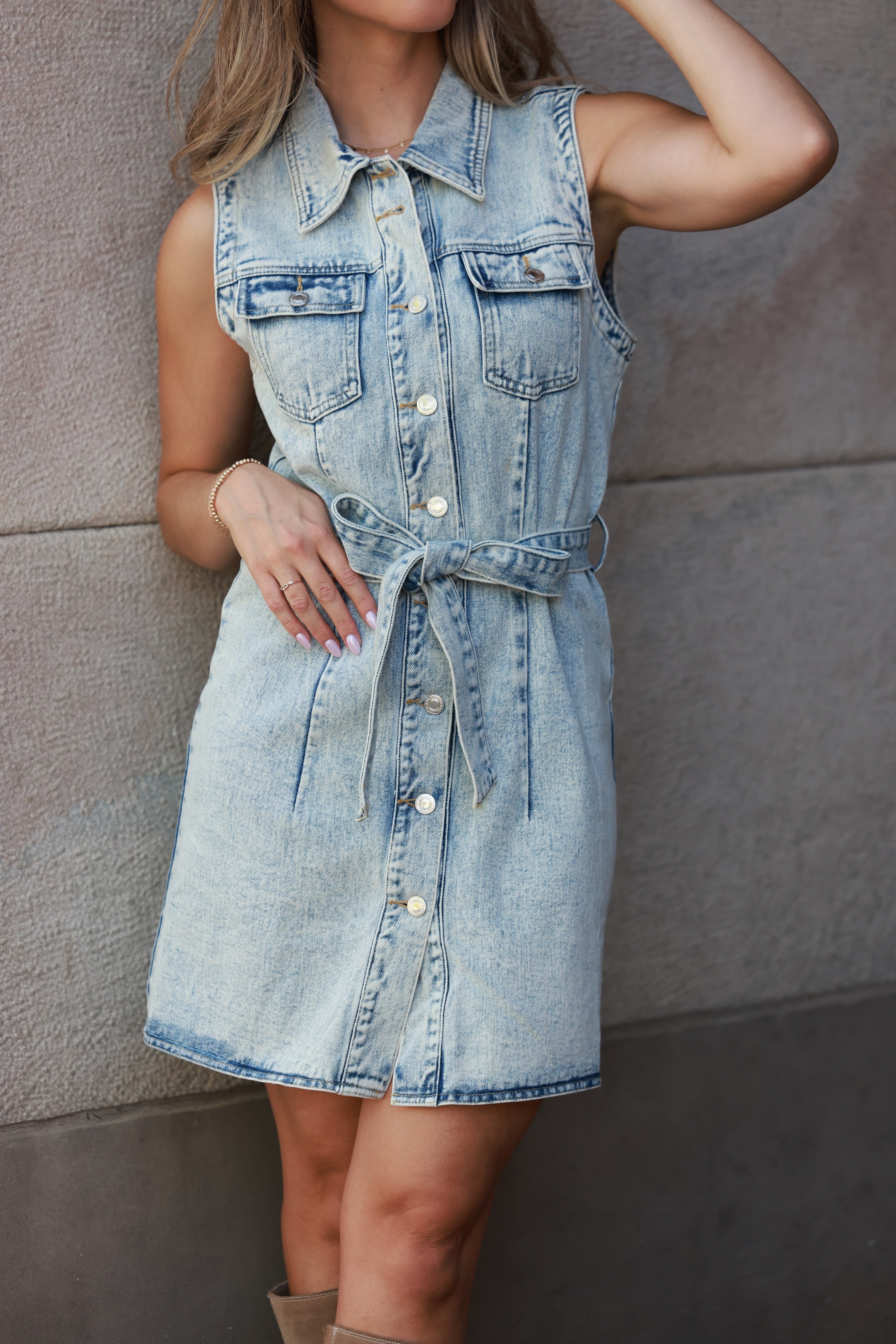 Denim dress worn by a person against a neutral wall - equestrian apparel, equestrian inspired apparel, horse show apparel, women's dress, equestrian dress