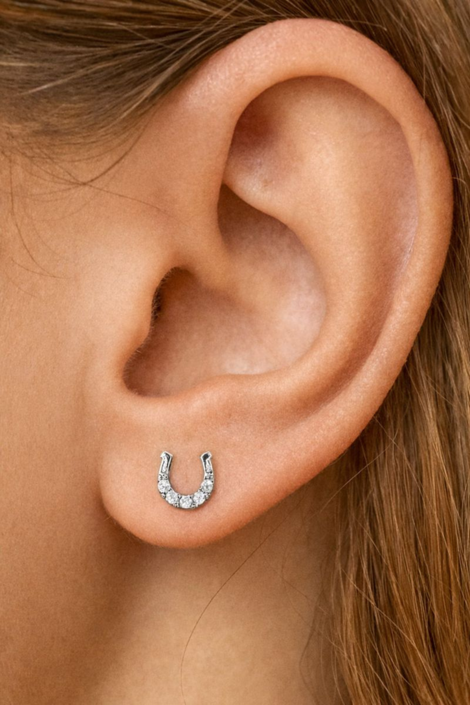 Dainty equestrian horseshoe stud earrings crafted from rhodium-plated brass with sparkling CZ accents.