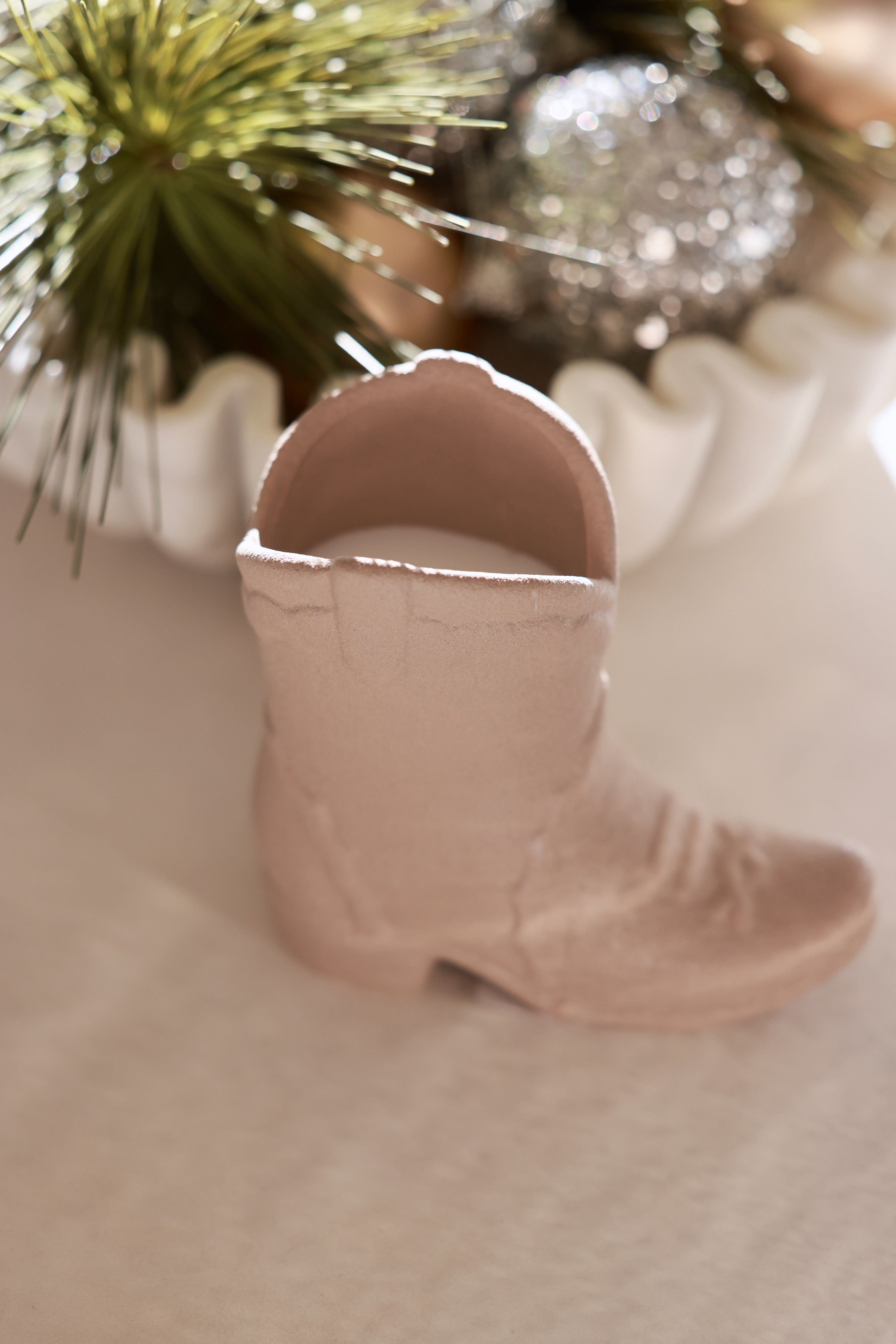 Matte tan ceramic cowboy boot candle with a cozy ranch-inspired scent of bergamot, mahogany, and amber. This western-style candle doubles as a keepsake container for pens or flowers, perfect for equestrian home décor and horse lover gifts.