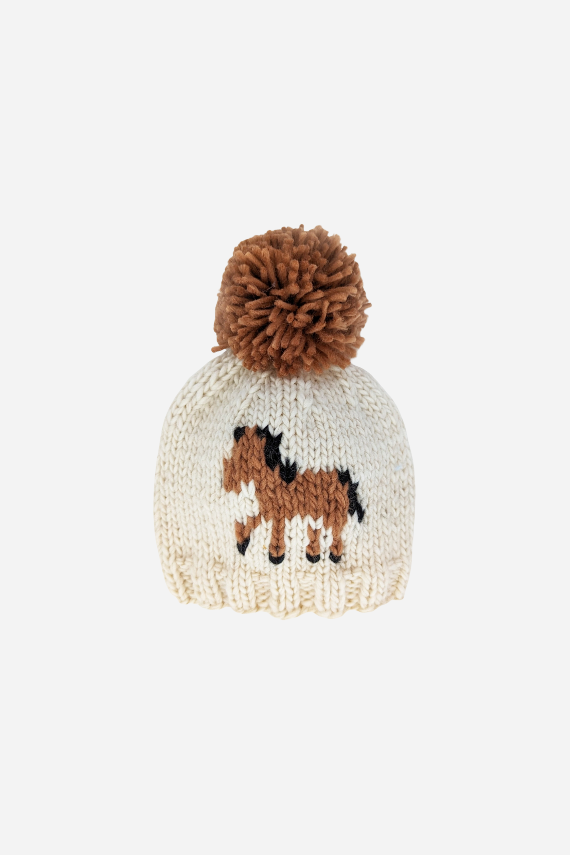 Hand-knit kids’ pony beanie in natural yarn with a pecan brown pony design on the front and a matching pecan pom-pom on top. Eco-friendly, sustainable equestrian-inspired winter hat for babies and children, made from recycled polyester and acrylic blend.