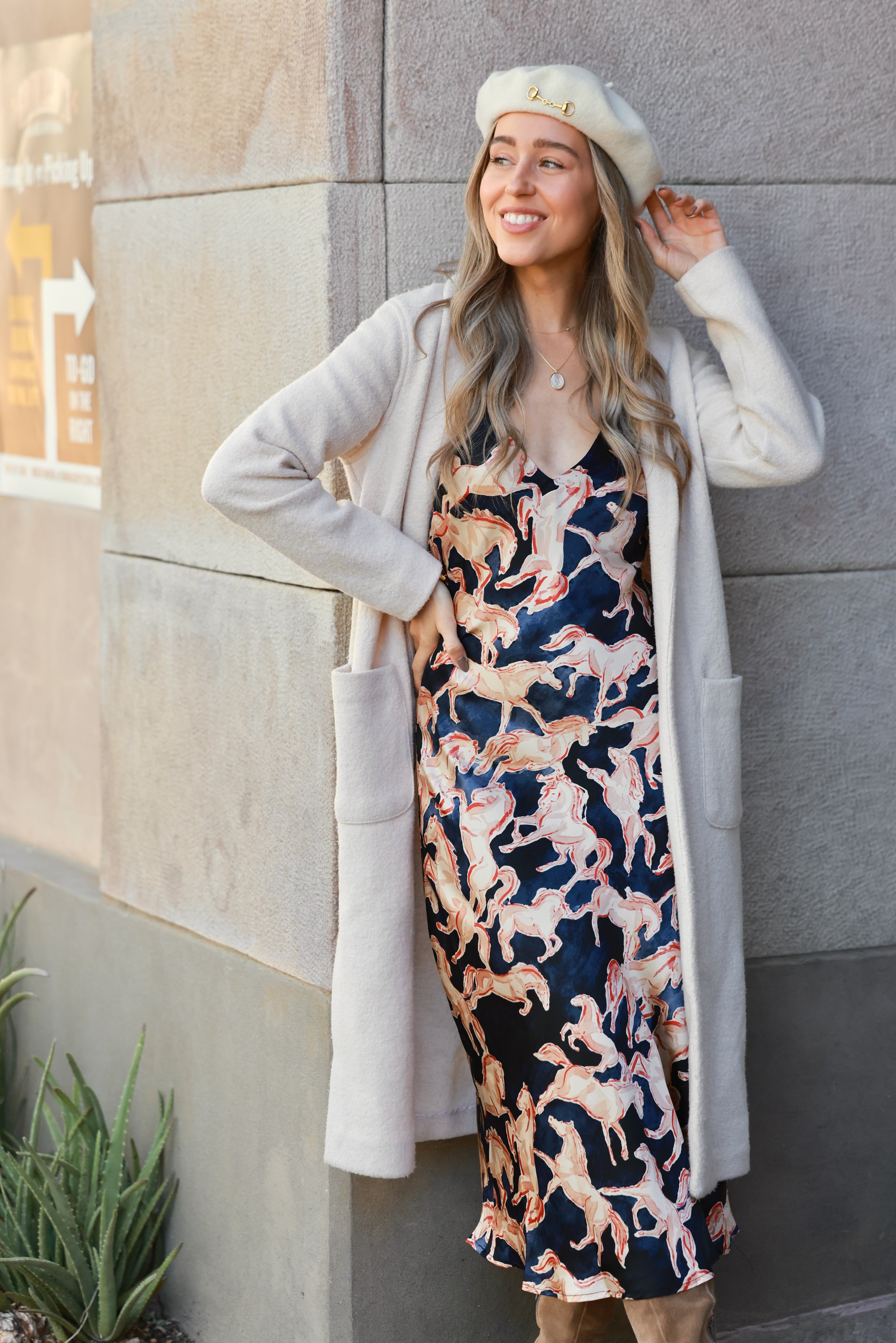 Woman wearing a dress with horse pattern against a neutral background - Western slip dress, Horse print satin dress, Bias cut midi dress, Navy equestrian dress, Vintage-inspired slip dress, Cocktail party dress, Day party outfit, Western navy satin dress, Women’s equestrian fashion, Retro western slip dress