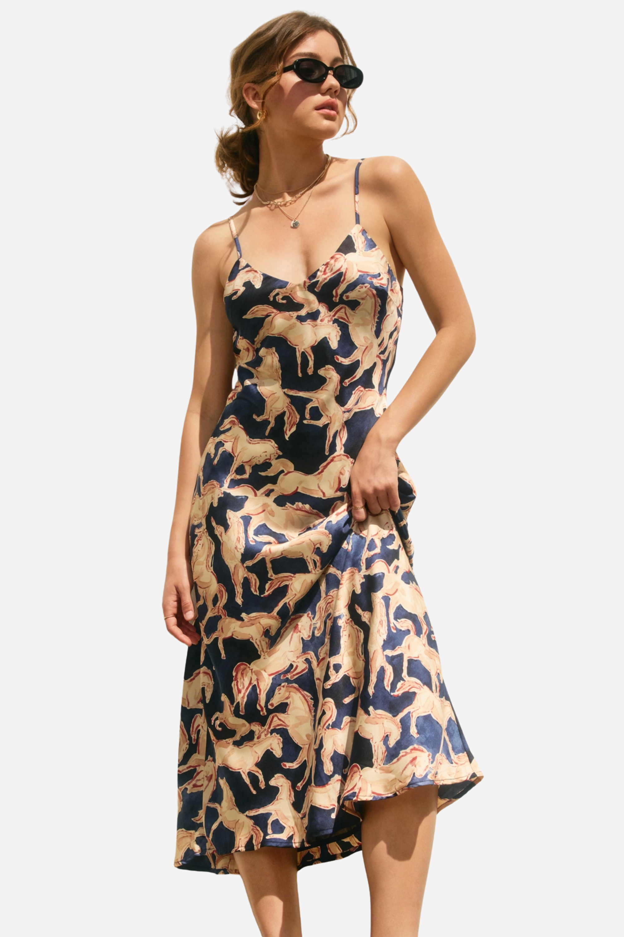 Woman wearing a dress with horse pattern against a neutral background - Western slip dress, Horse print satin dress, Bias cut midi dress, Navy equestrian dress, Vintage-inspired slip dress, Cocktail party dress, Day party outfit, Western navy satin dress, Women’s equestrian fashion, Retro western slip dress
