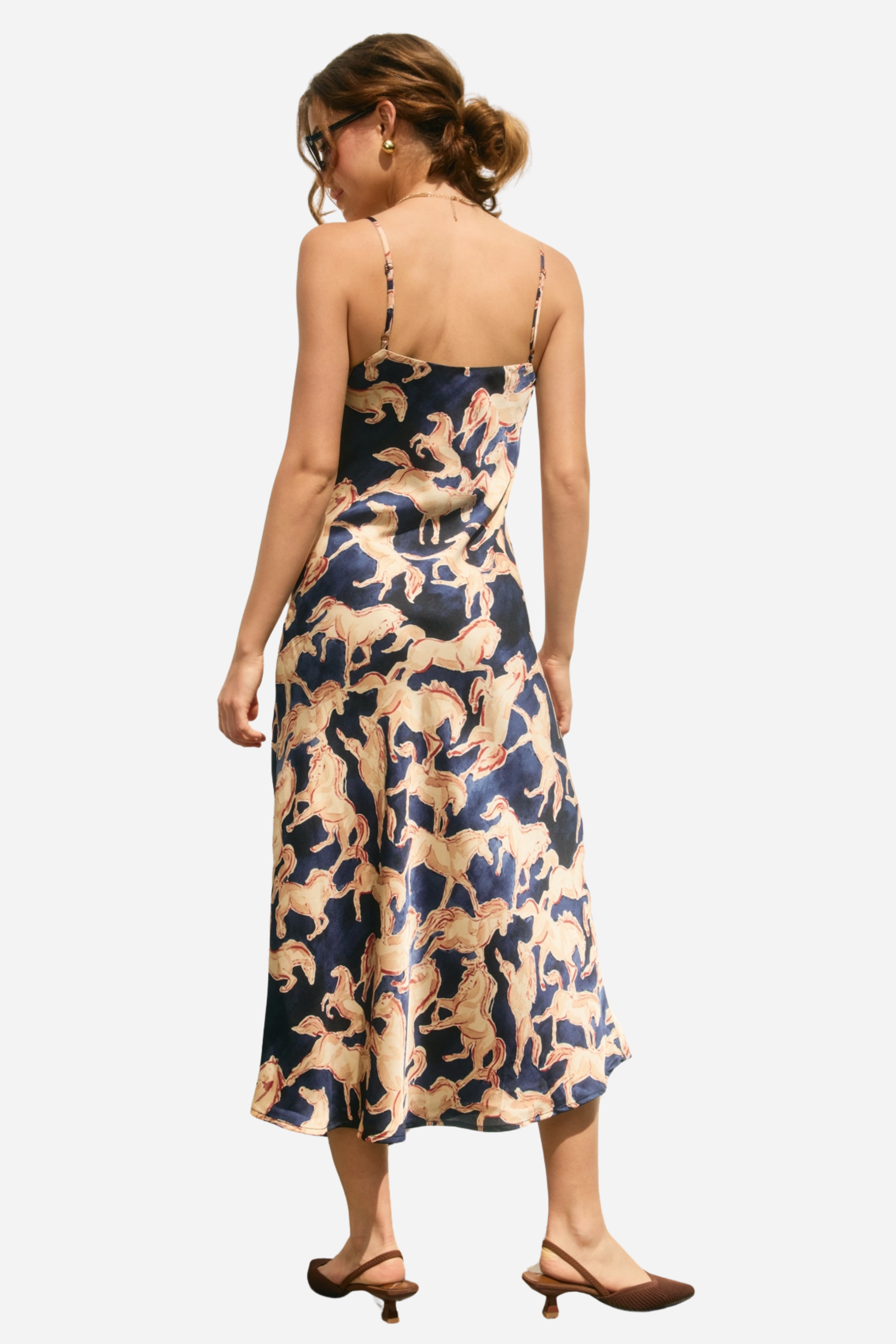 Woman wearing a dress with horse pattern against a neutral background - Western slip dress, Horse print satin dress, Bias cut midi dress, Navy equestrian dress, Vintage-inspired slip dress, Cocktail party dress, Day party outfit, Western navy satin dress, Women’s equestrian fashion, Retro western slip dress