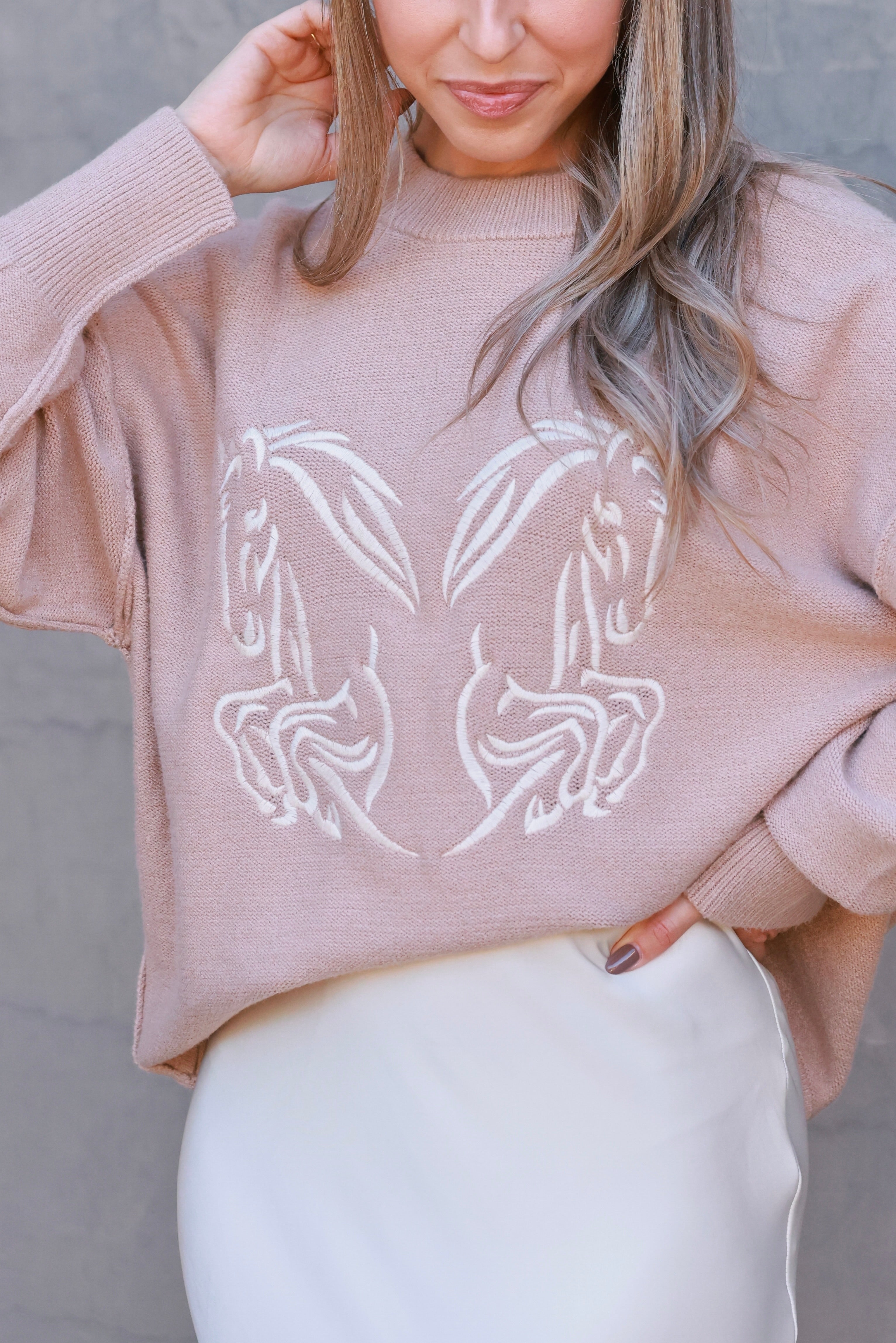 Roxy Embroidered Horse Sweater featuring tonal twin horse embroidery symbolizing strength and movement. Crafted from a soft viscose-poly-nylon blend with dropped shoulders, exposed seams, and side-split hem. A relaxed, minimalist equestrian sweater blending comfort and sophistication.