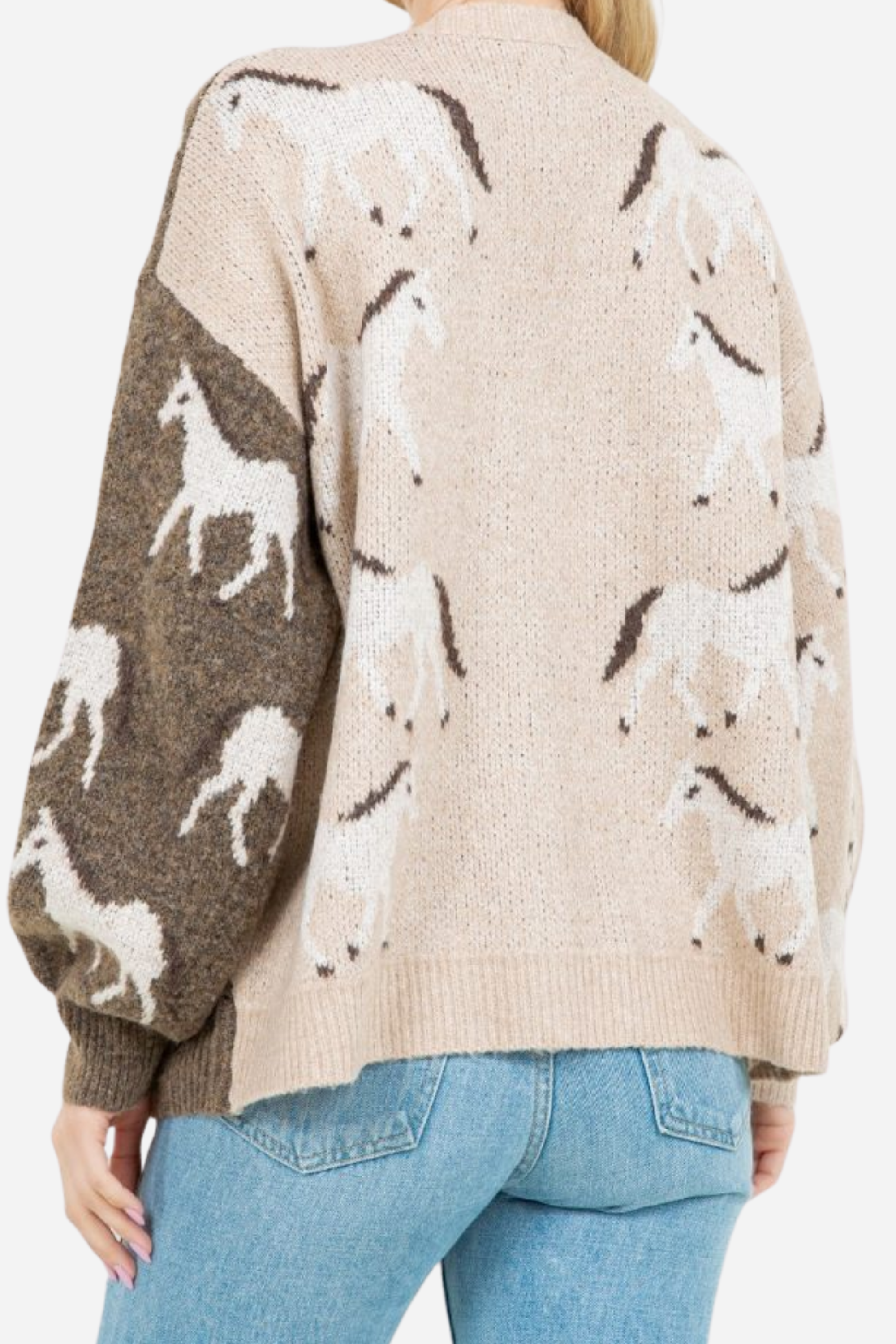 Woman wearing an asymmetric open-front cardigan in brown and beige with white horse patterns. This cozy equestrian cardigan blends rustic western style with casual horse girl apparel, soft, stretchy knit perfect for everyday wear.