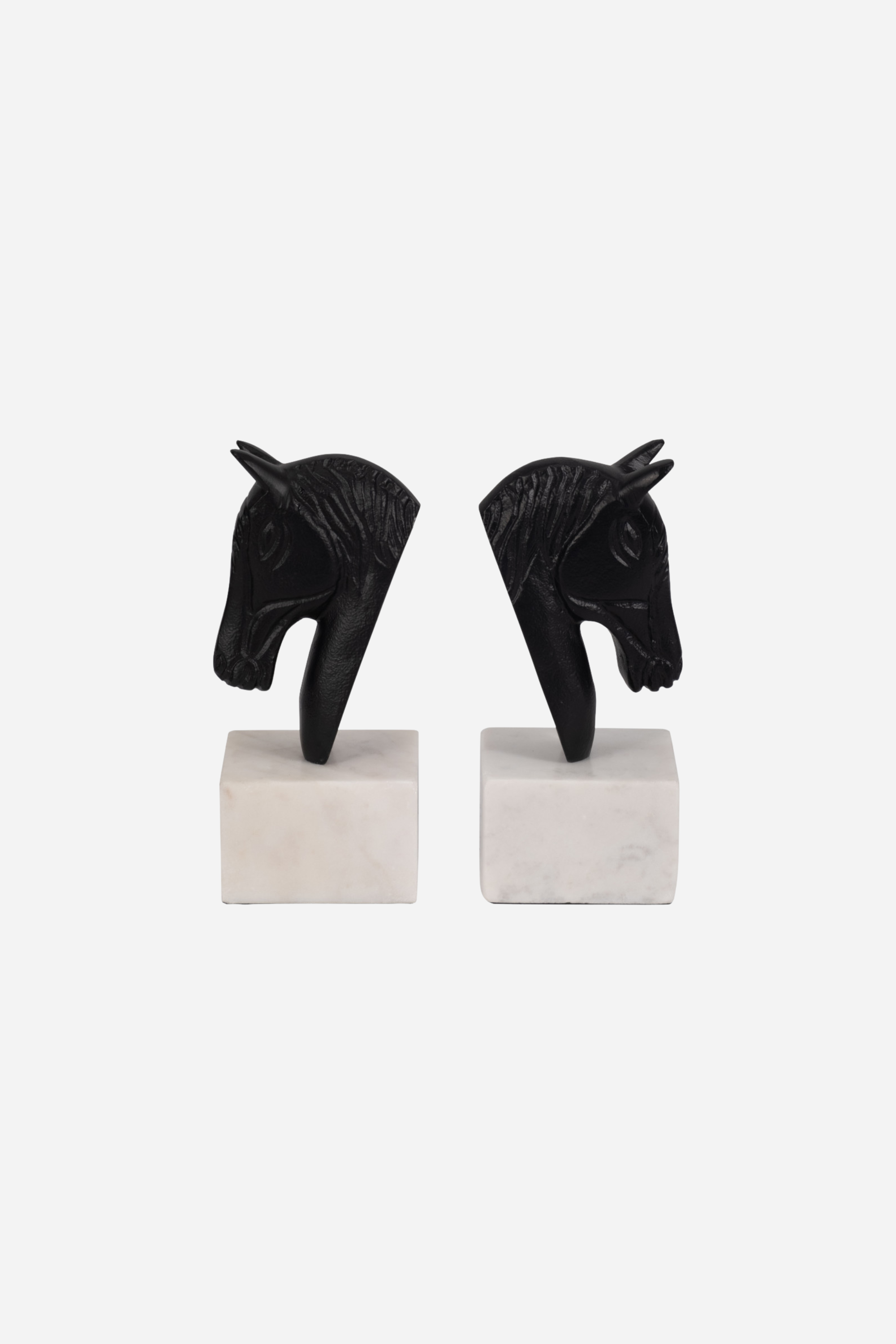 Set of two metal horse head bookends with sleek black and white aluminum design and solid marble bases. Elegant equestrian-inspired home décor perfect for elevating a bookshelf, office, or home library while securely holding books with timeless style.