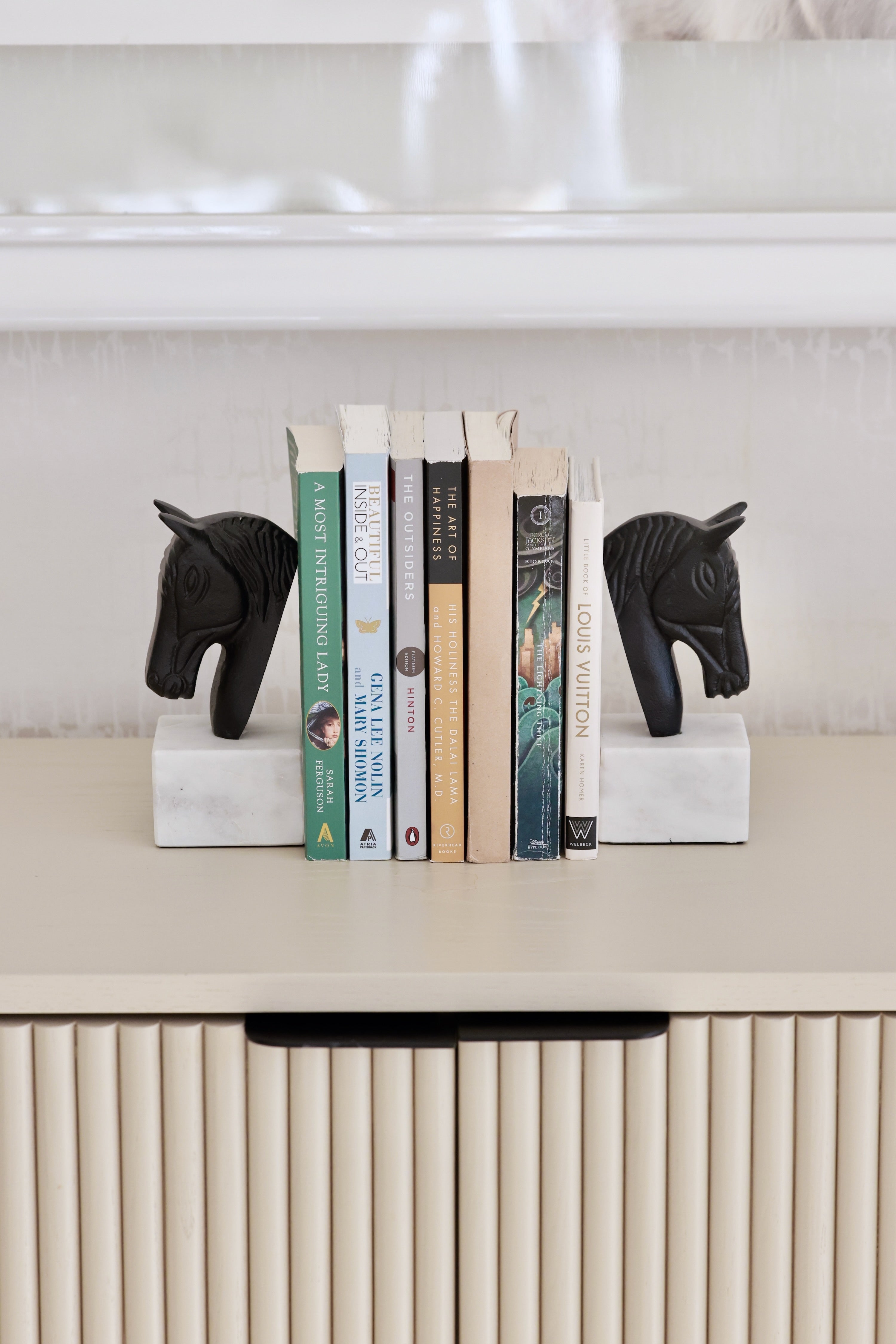 Set of two metal horse head bookends with sleek black and white aluminum design and solid marble bases. Elegant equestrian-inspired home décor perfect for elevating a bookshelf, office, or home library while securely holding books with timeless style.