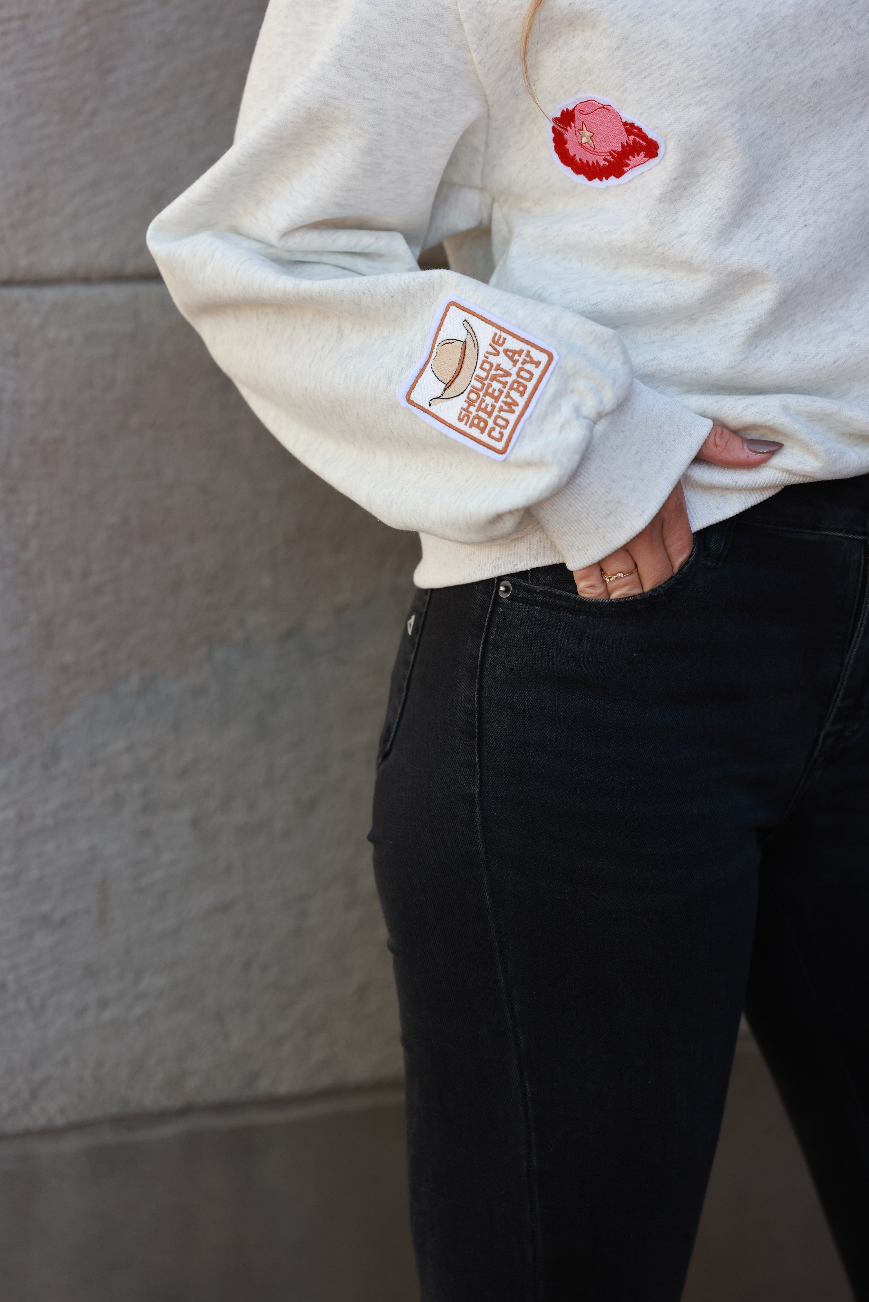 Stay Wild Patch Sweatshirt crafted from soft cotton with raglan sleeves and ribbed cuffs, neck, and hemline. Features a curated mix of western-inspired patches for a bold, adventurous equestrian look. True to size with an optional oversized fit for casual horse-girl style.