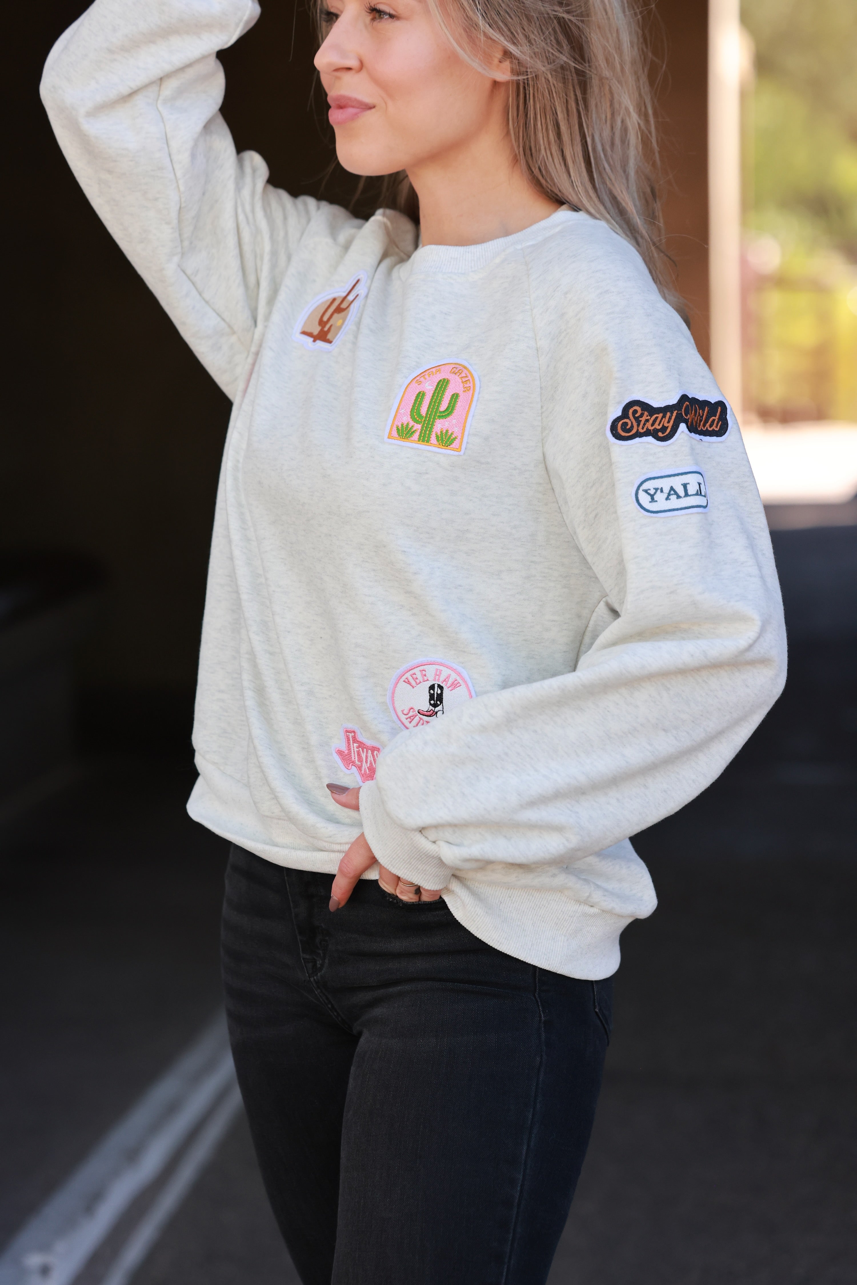 Stay Wild Patch Sweatshirt crafted from soft cotton with raglan sleeves and ribbed cuffs, neck, and hemline. Features a curated mix of western-inspired patches for a bold, adventurous equestrian look. True to size with an optional oversized fit for casual horse-girl style.