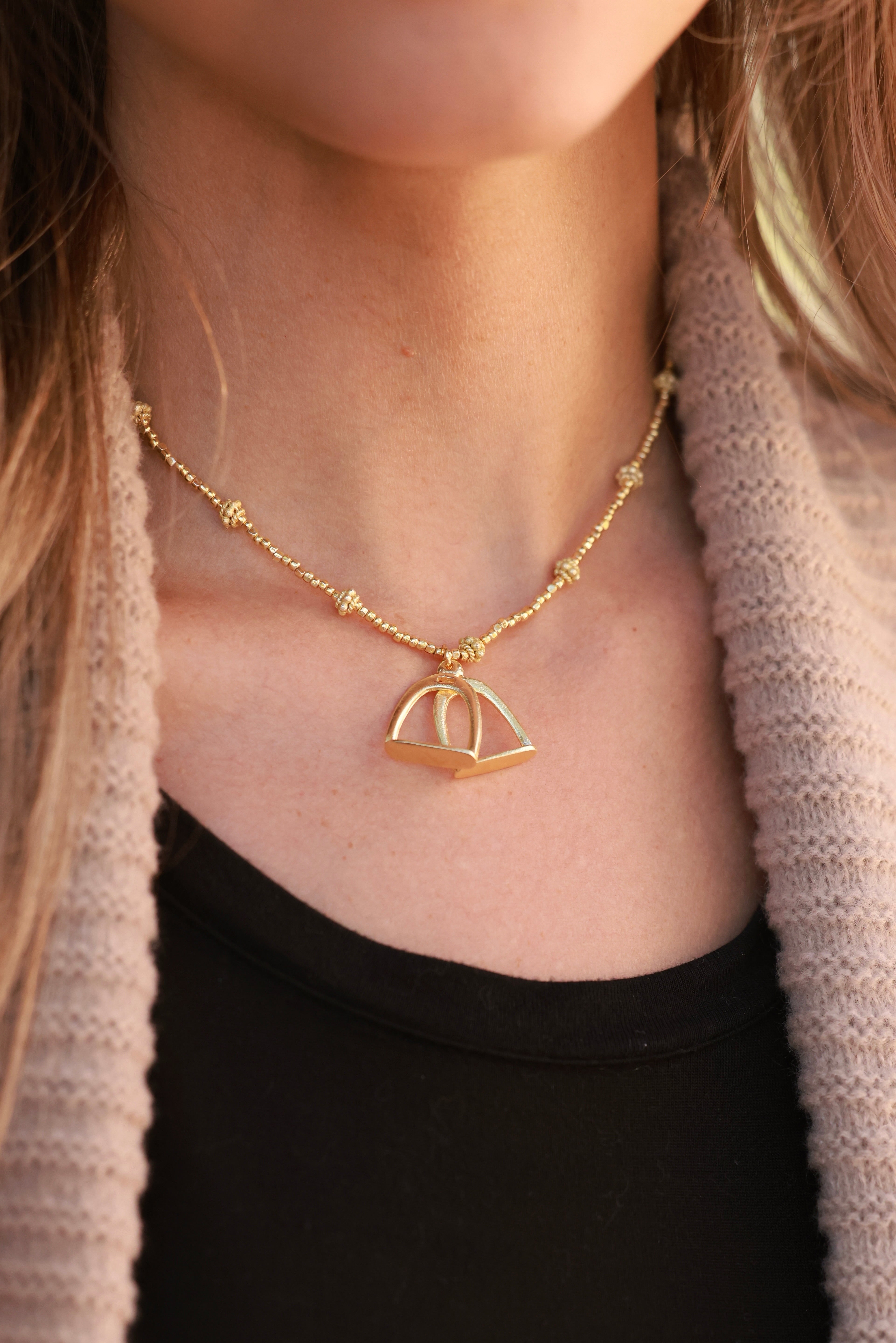 Delicate and dazzling stirrup necklace with lightweight stirrups strung between shimmering beads. 15-inch length with adjustable extender chain.