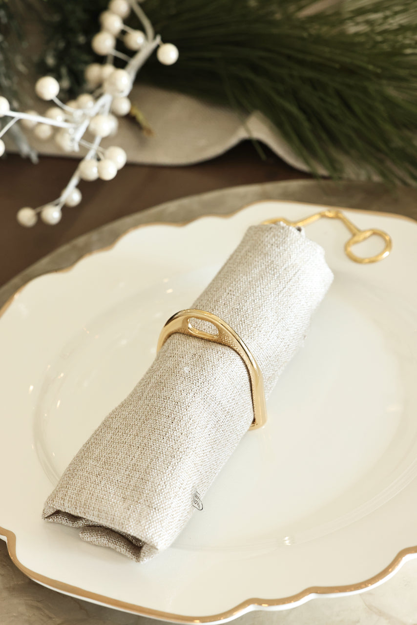 Gold Stirrup Napkin Ring Set featuring four polished brass stirrup-shaped rings with leather top closure for easy storage. Elegant equestrian-inspired table décor perfect for entertaining or gifting to horse lovers.