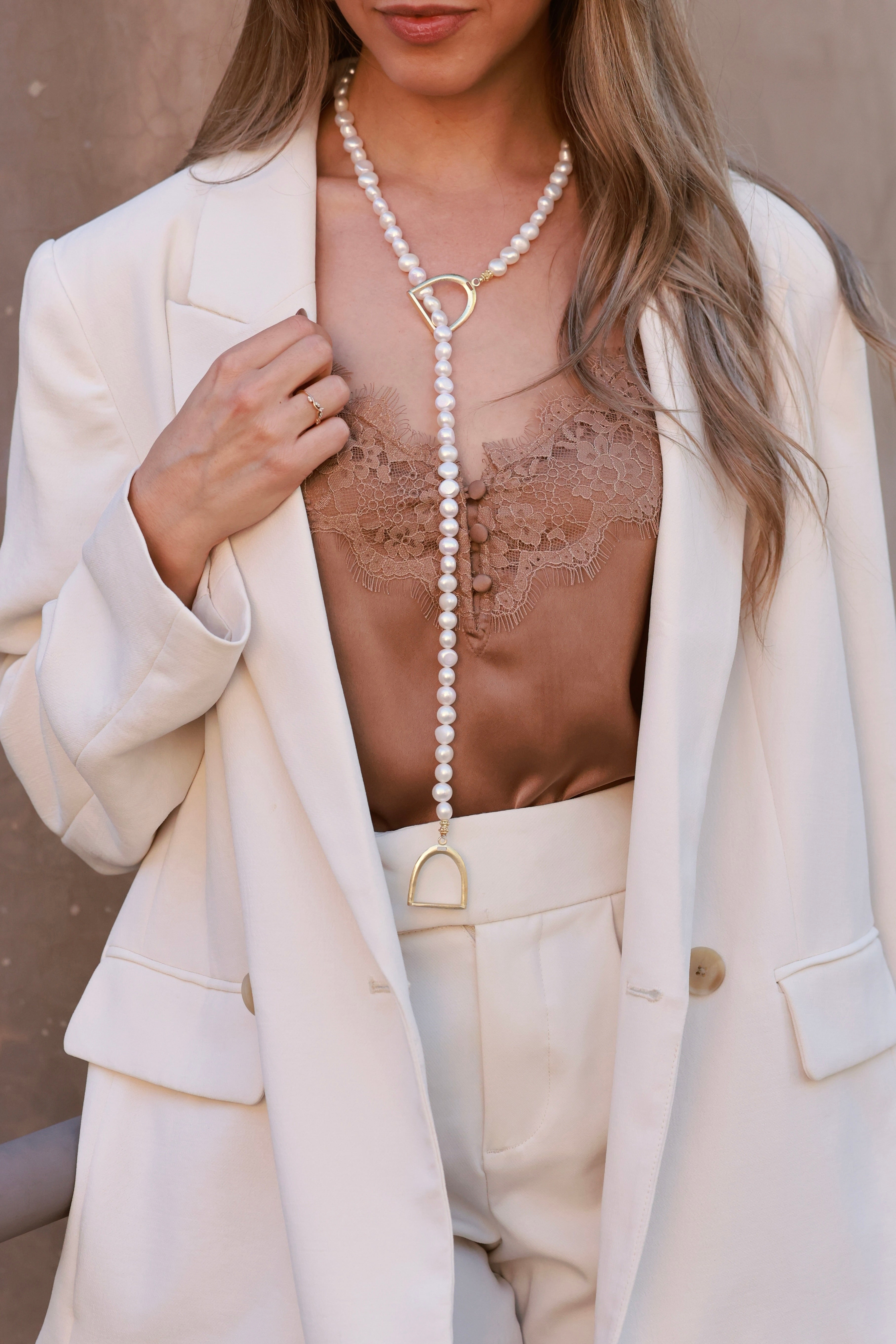 Stirrup Pearl Lariat Necklace with freshwater-style pearls and lightweight stirrup ends. Adjustable loop design, delicate and elegant for everyday wear.
