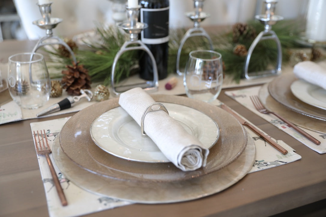 lilo collections stylish equestrian stirrup napkin ring set Silver Stirrup Napkin Ring Set featuring four polished silver stirrup-shaped rings with a leather top closure for easy storage. A best-selling equestrian-inspired table accessory perfect for elegant dining or gifting to horse lovers.