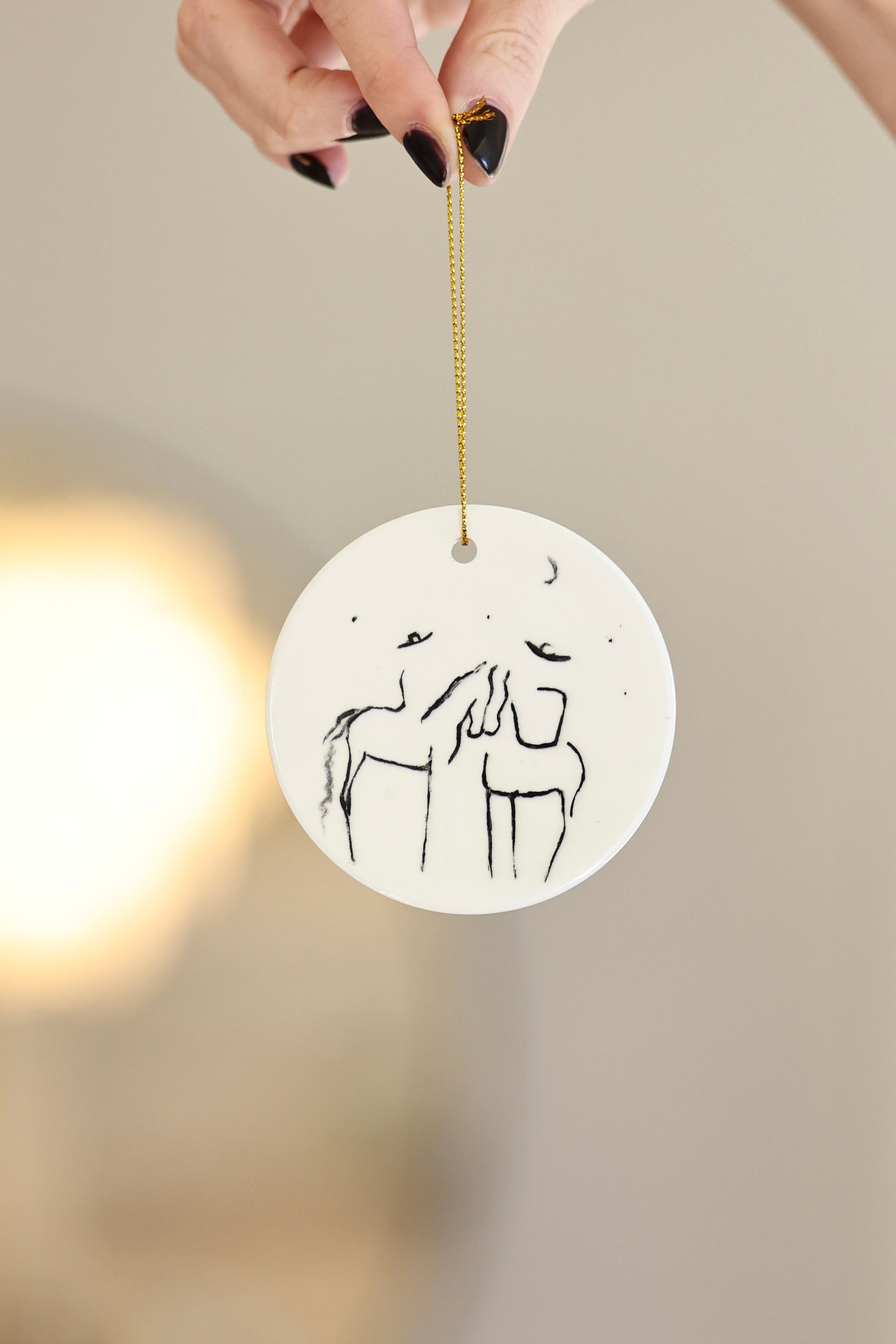 Under The Stars Ornament — ceramic equestrian-inspired Christmas ornament featuring original horse artwork by Bettina, strung with gold tinsel. Perfect horse-themed holiday gift for equestrians and horse lovers. Made in the USA.