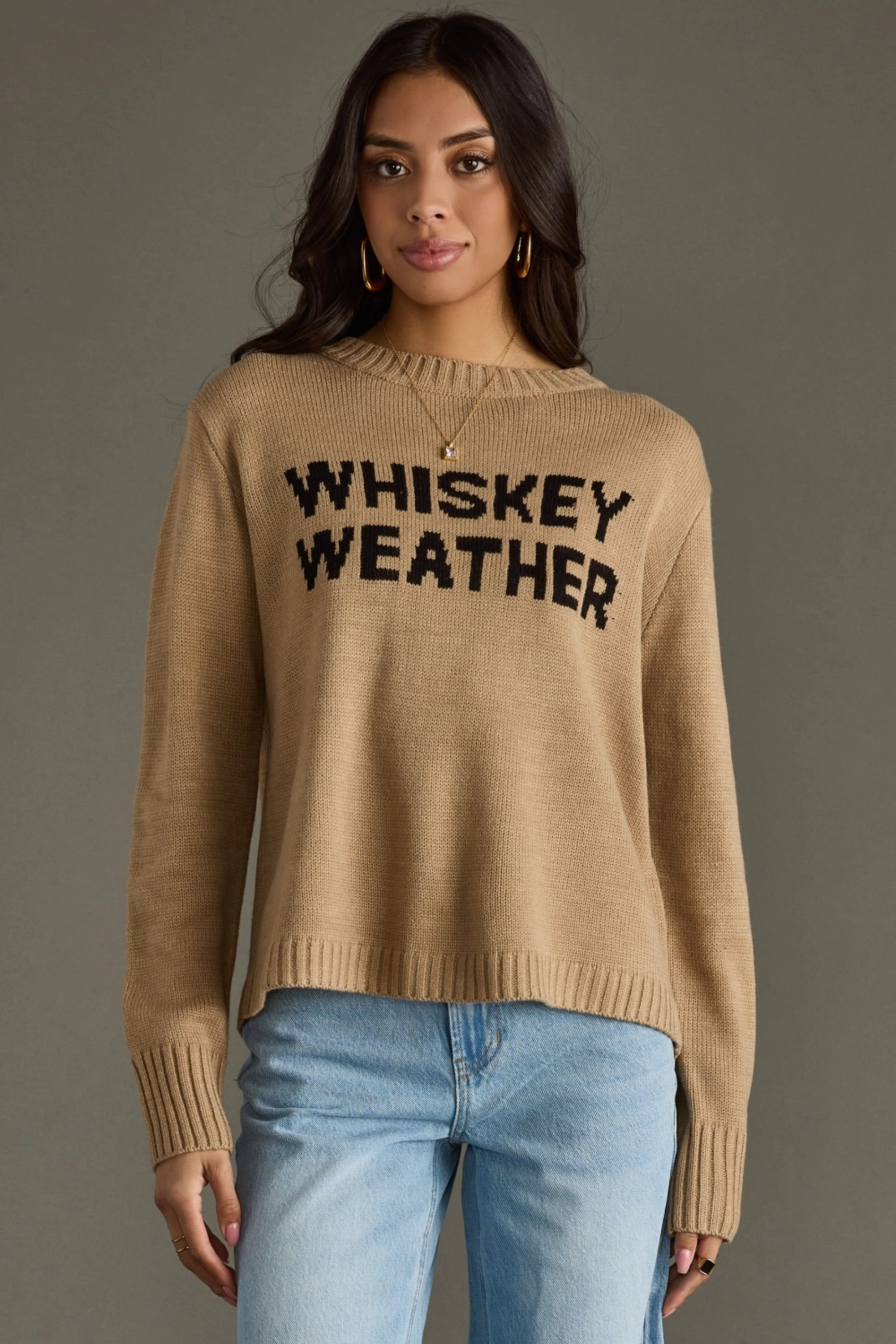 Woman wearing a beige sweater with 'WHISKEY WEATHER' text against a gray background - Whiskey weather sweater, Western graphic sweater, Fall country sweater, Taupe knit pullover, Cowgirl whiskey sweater