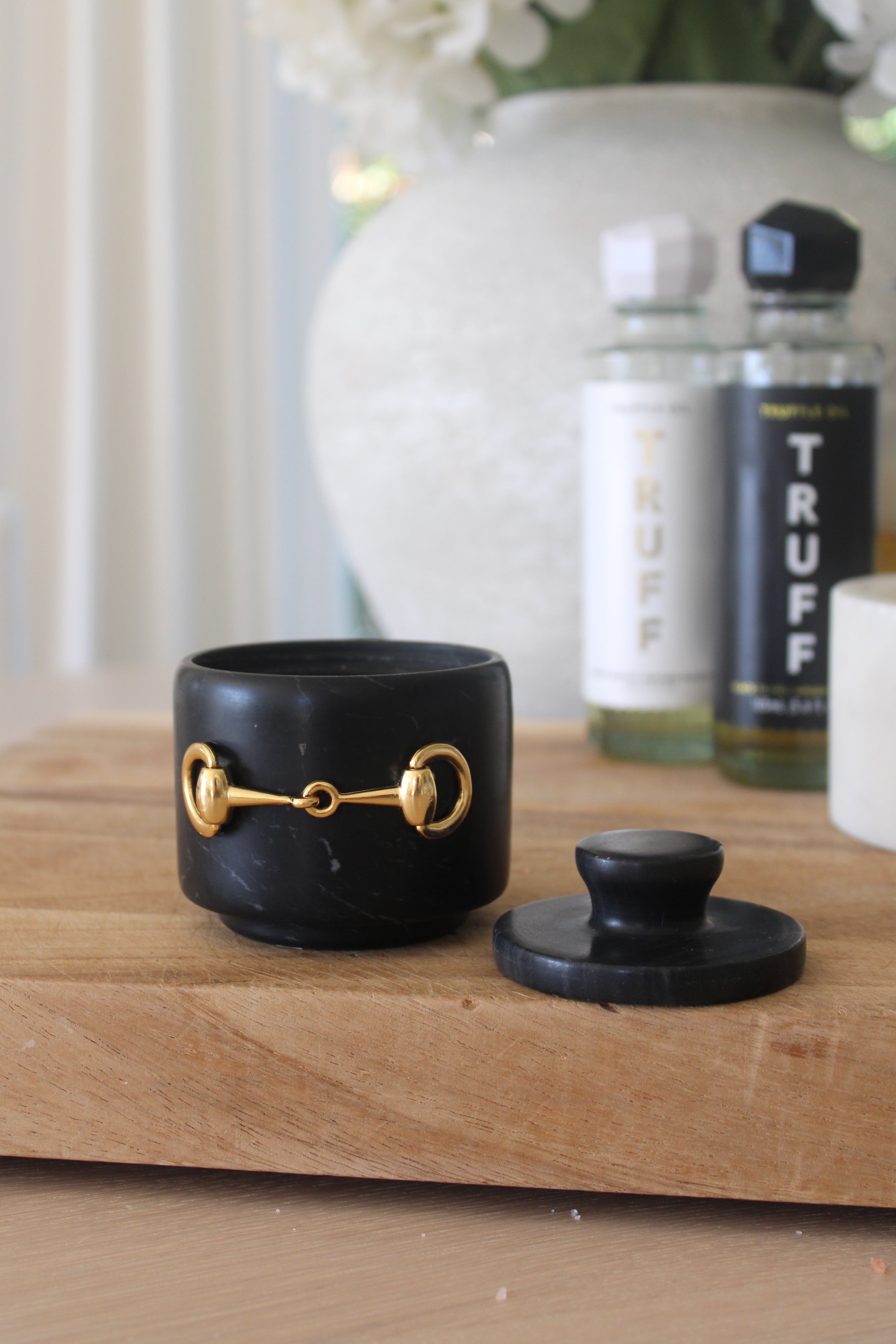 Elegant black marble D-ring salt cellar with gold hardware and matching lid, handcrafted for an equestrian-inspired kitchen. The round marble container features a sleek matte finish and natural veining, perfect for storing gourmet salts, spices, or herbs while adding sophisticated horse-themed decor to any table or countertop.