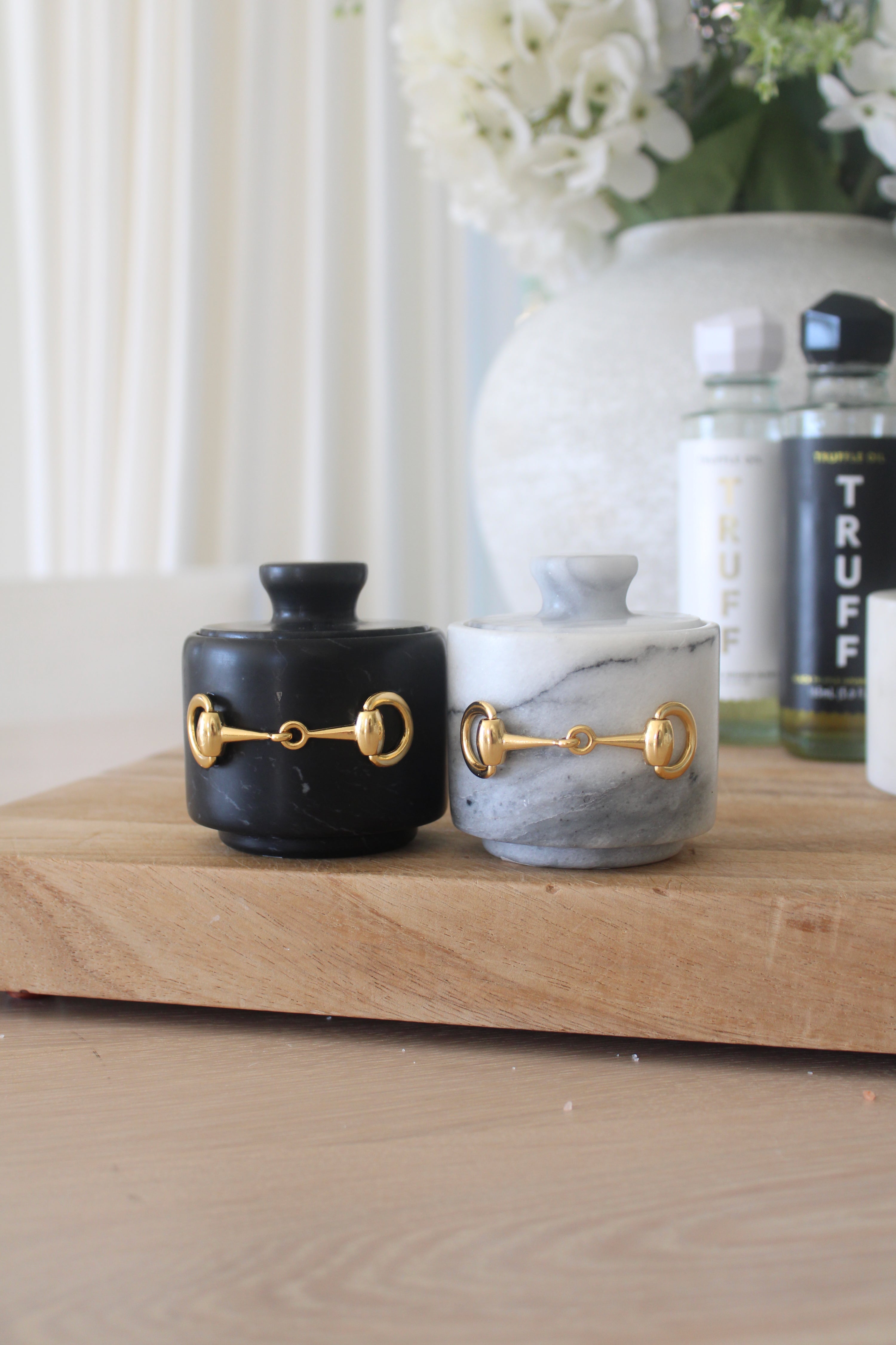 Elegant black marble D-ring salt cellar with gold hardware and matching lid, handcrafted for an equestrian-inspired kitchen. The round marble container features a sleek matte finish and natural veining, perfect for storing gourmet salts, spices, or herbs while adding sophisticated horse-themed decor to any table or countertop.